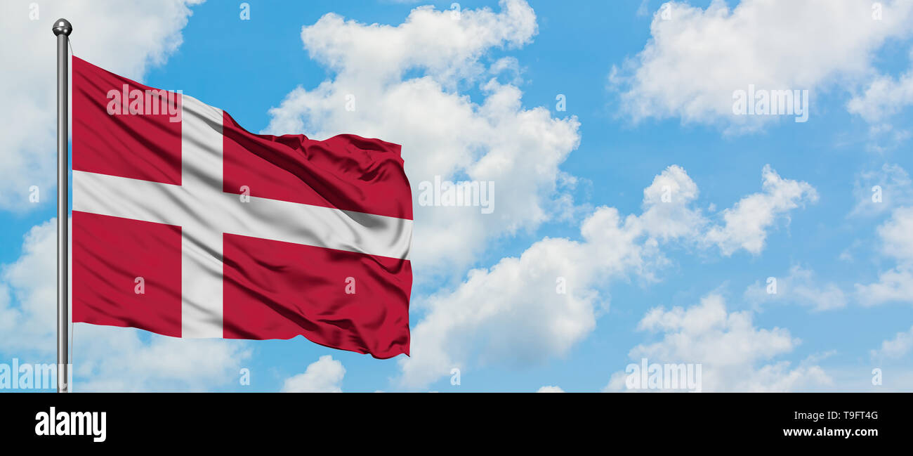 Denmark flag waving in the wind against white cloudy blue sky. Diplomacy concept, international relations. Stock Photo