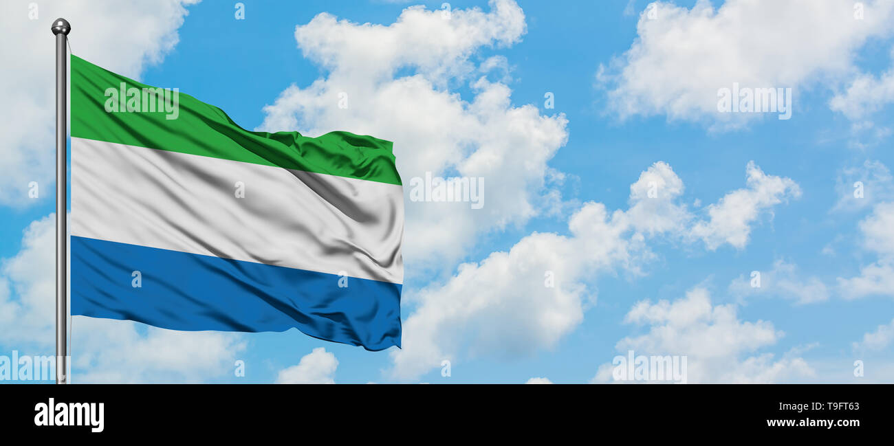 Sierra Leone flag waving in the wind against white cloudy blue sky ...