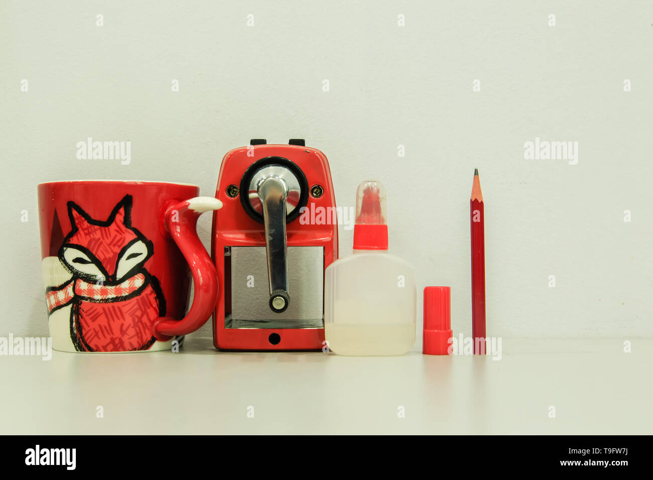 Red pencil sharpener machine with cup and glue on white background Stock Photo