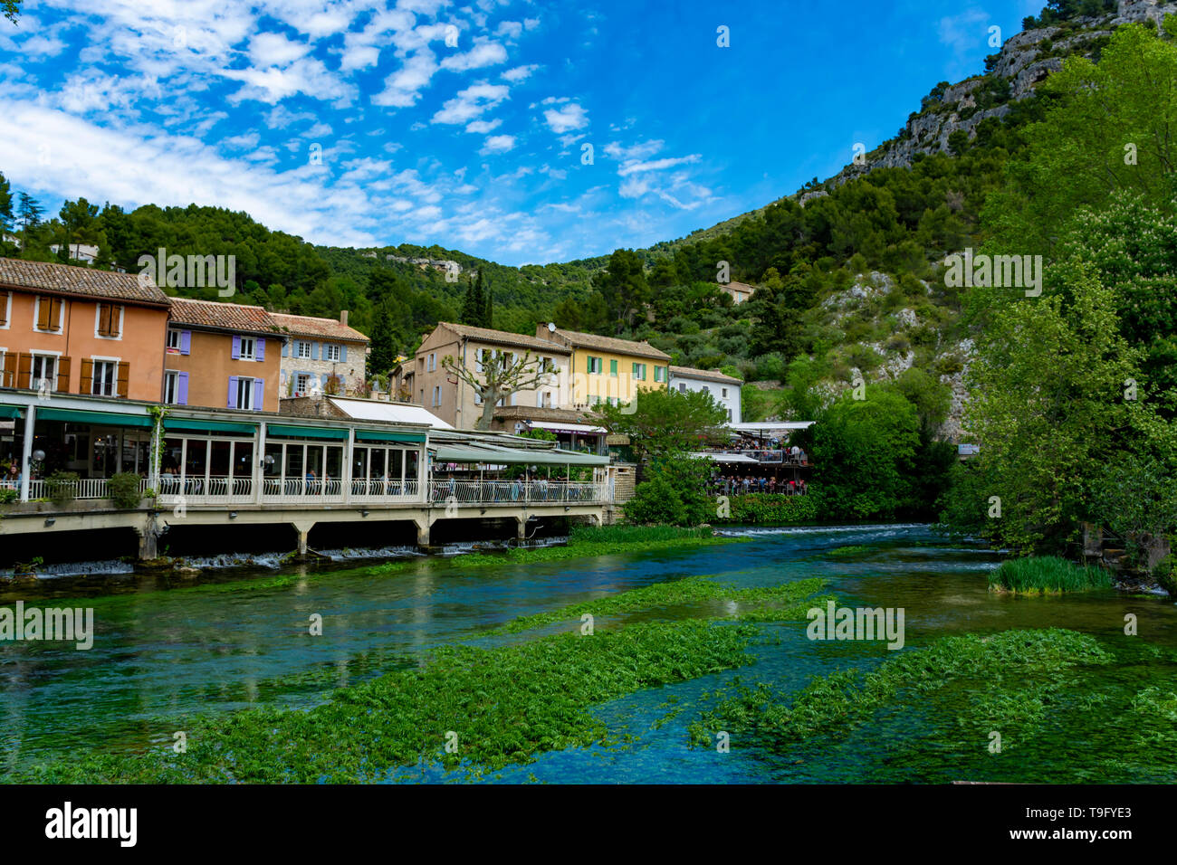 South of France, view on small touristic Provencal town of poet Petrarch Fontaine-de-vaucluse with emerald green waters of Sorgue river Stock Photo