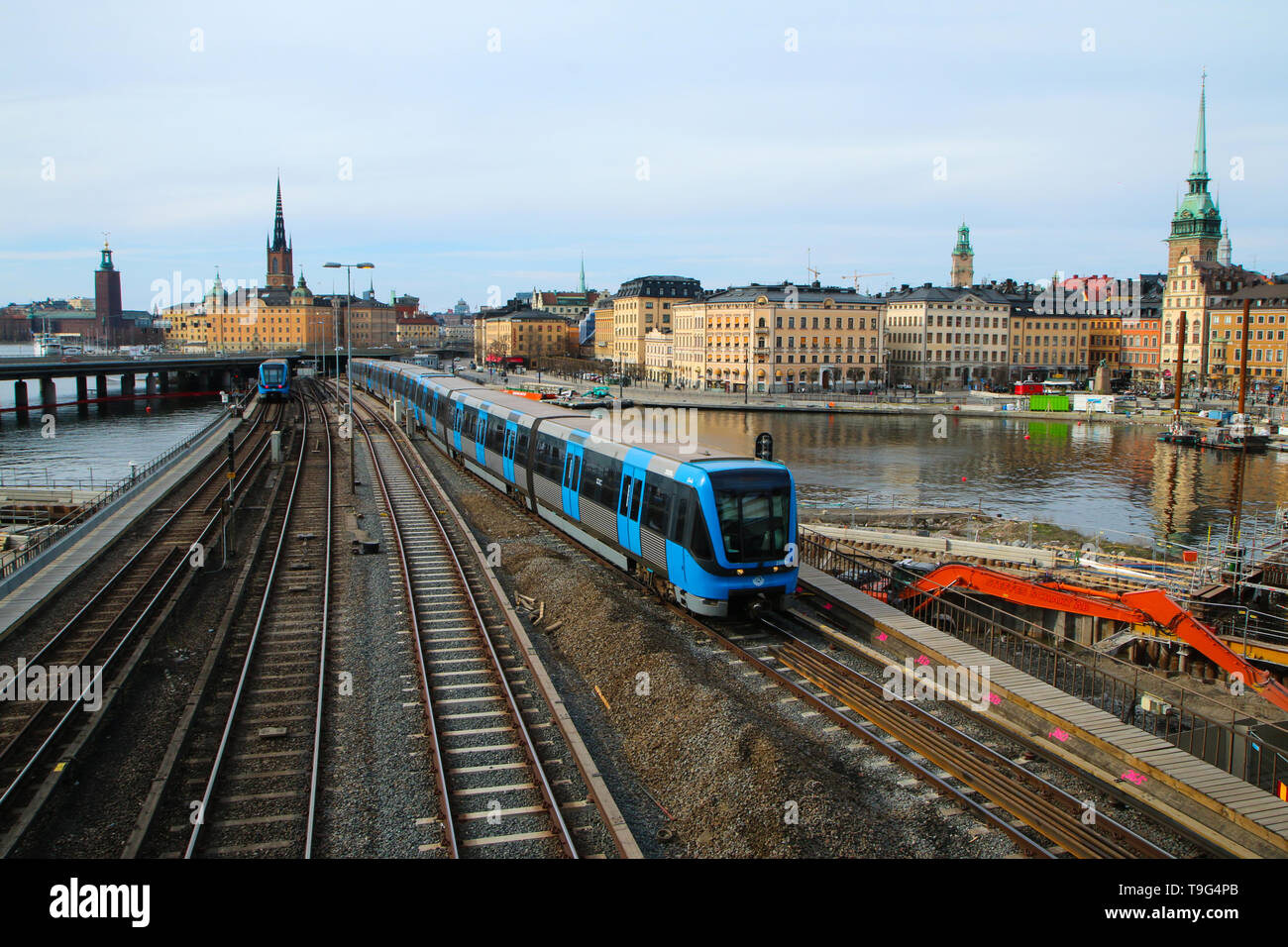 A traditional modern swedish metro train in Stockholm is driving on the bridge from the old town centrum. The train is isolated in a black and white Stock Photo