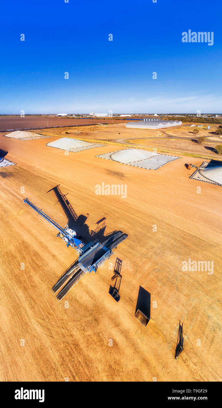 Industrial machinery and grain loader at bulk storage warehouse site in the middle of wheat belt artesian basing agricultural region in rural outback  Stock Photo