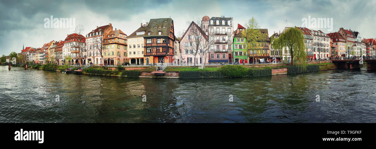 Spring panorama of Strasbourg city in front of Quai des Bateliers street along water canal. Fachwerk timber framing colorful houses. Traditional archi Stock Photo