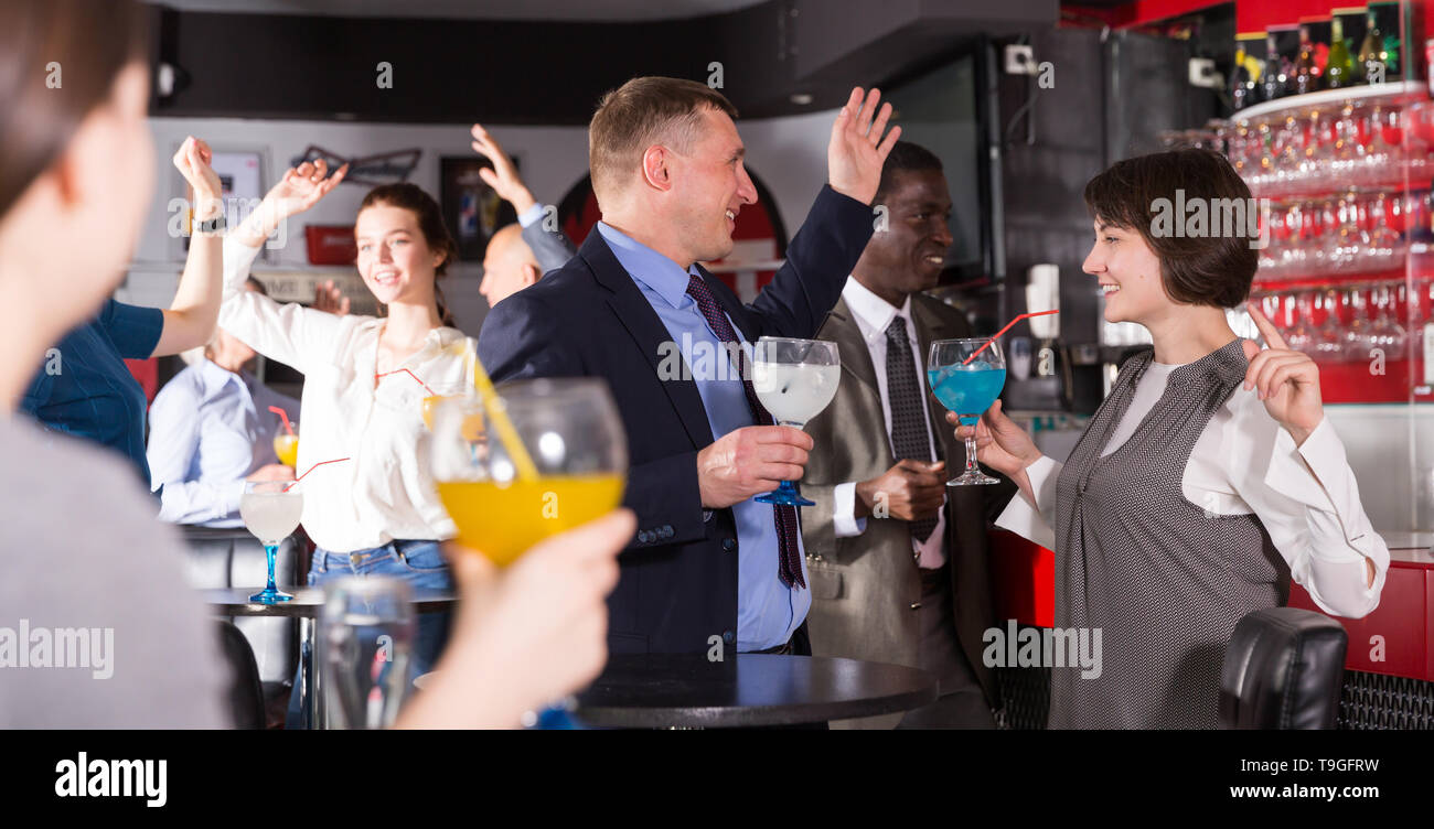 Smiling man and woman drinking alcohol and having conversation on ...