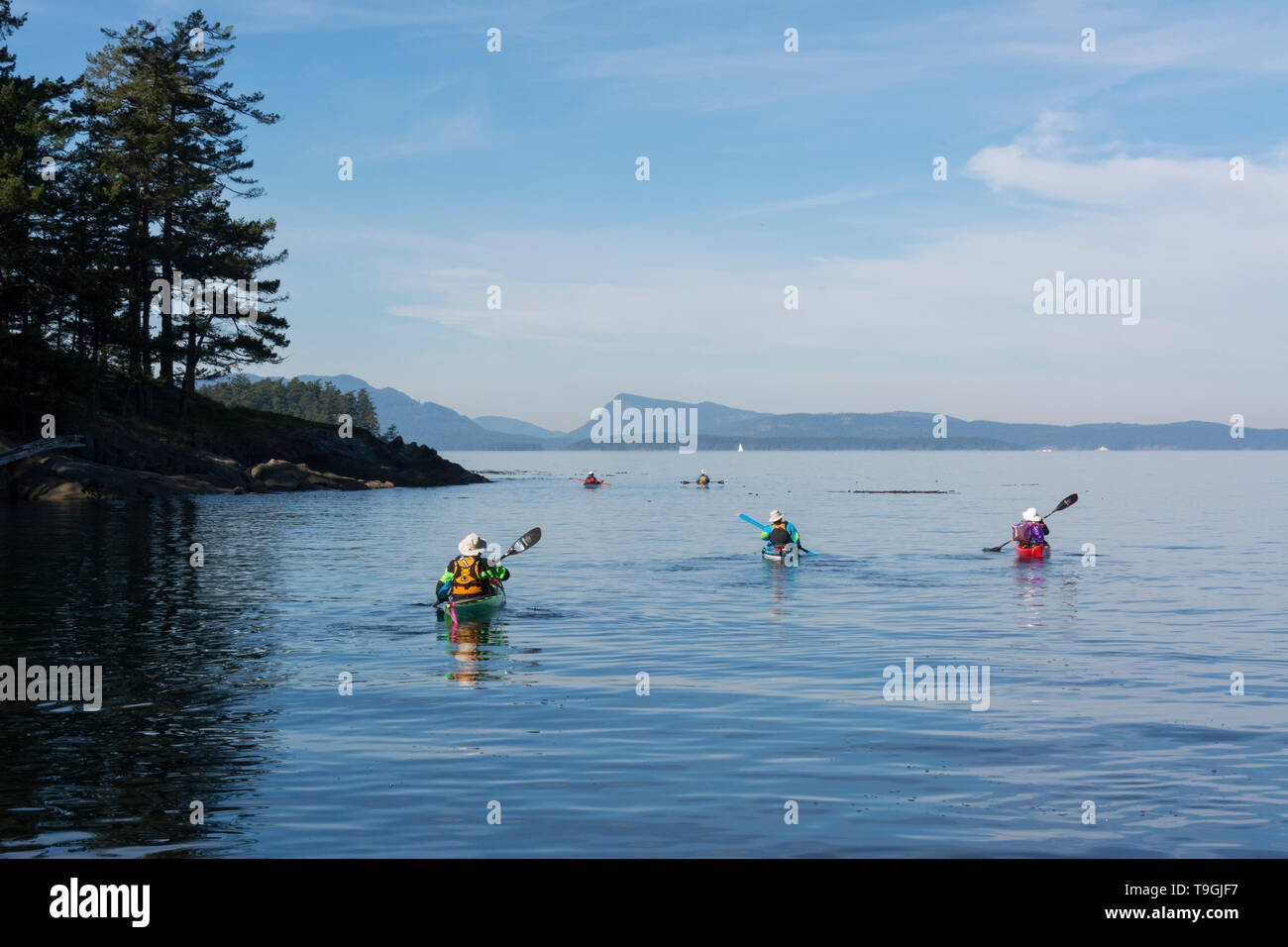 Sea kayakers depart Isle-de-Lis, commonly known as Rum Island, towards Sidney, Gulf Islands National Park Stock Photo