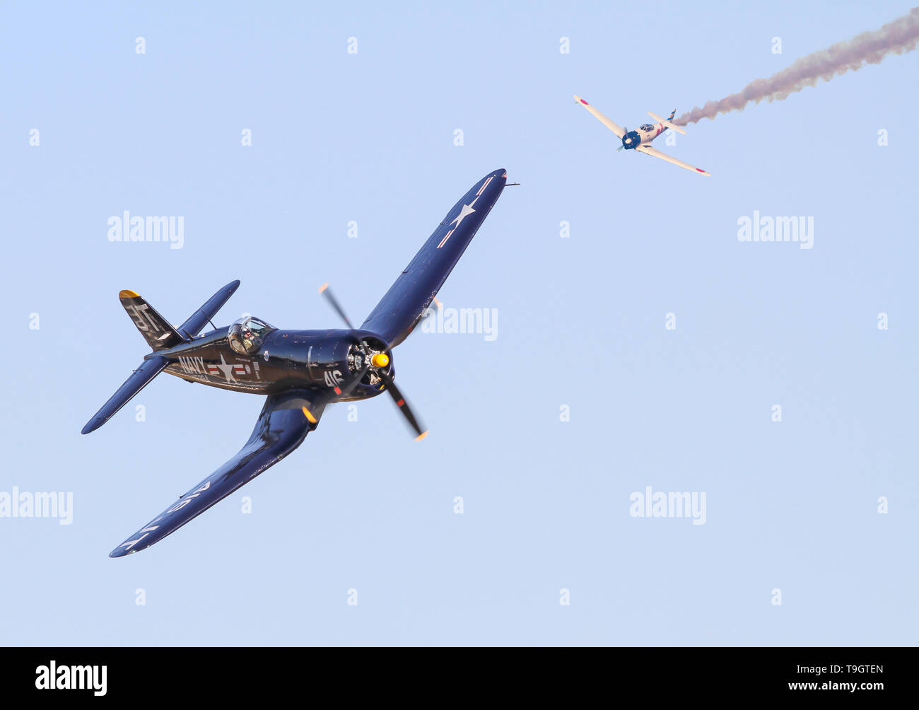 A Japanese Zero fighter plane pursues a U.S. Vought F4U Corsair fighter in a recreation of a World War II dogfight in the Pacific Theater. Stock Photo