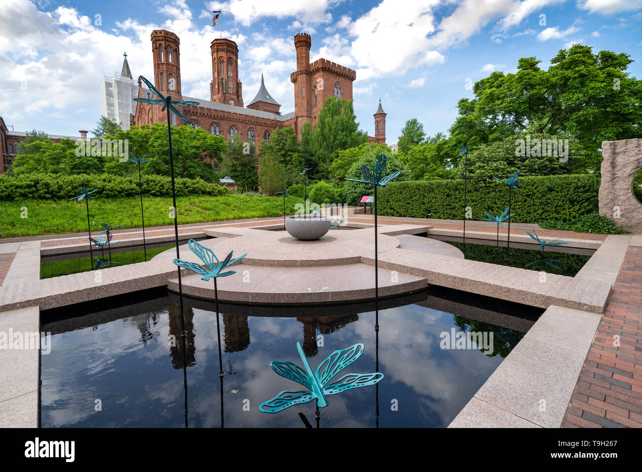 Washington, DC - May 9, 2019: The Moongate Garden with dragonfly statues in the Enid Haupt Garden and the Smithsonian Castle on the National Mall Stock Photo