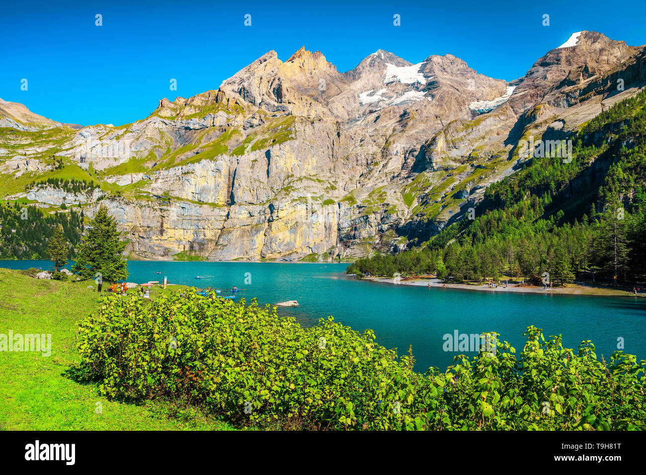 Popular travel and tourism location, beautiful alpine lake and snowy mountains with glaciers, Oeschinensee lake, Bernese Oberland, Switzerland, Europe Stock Photo
