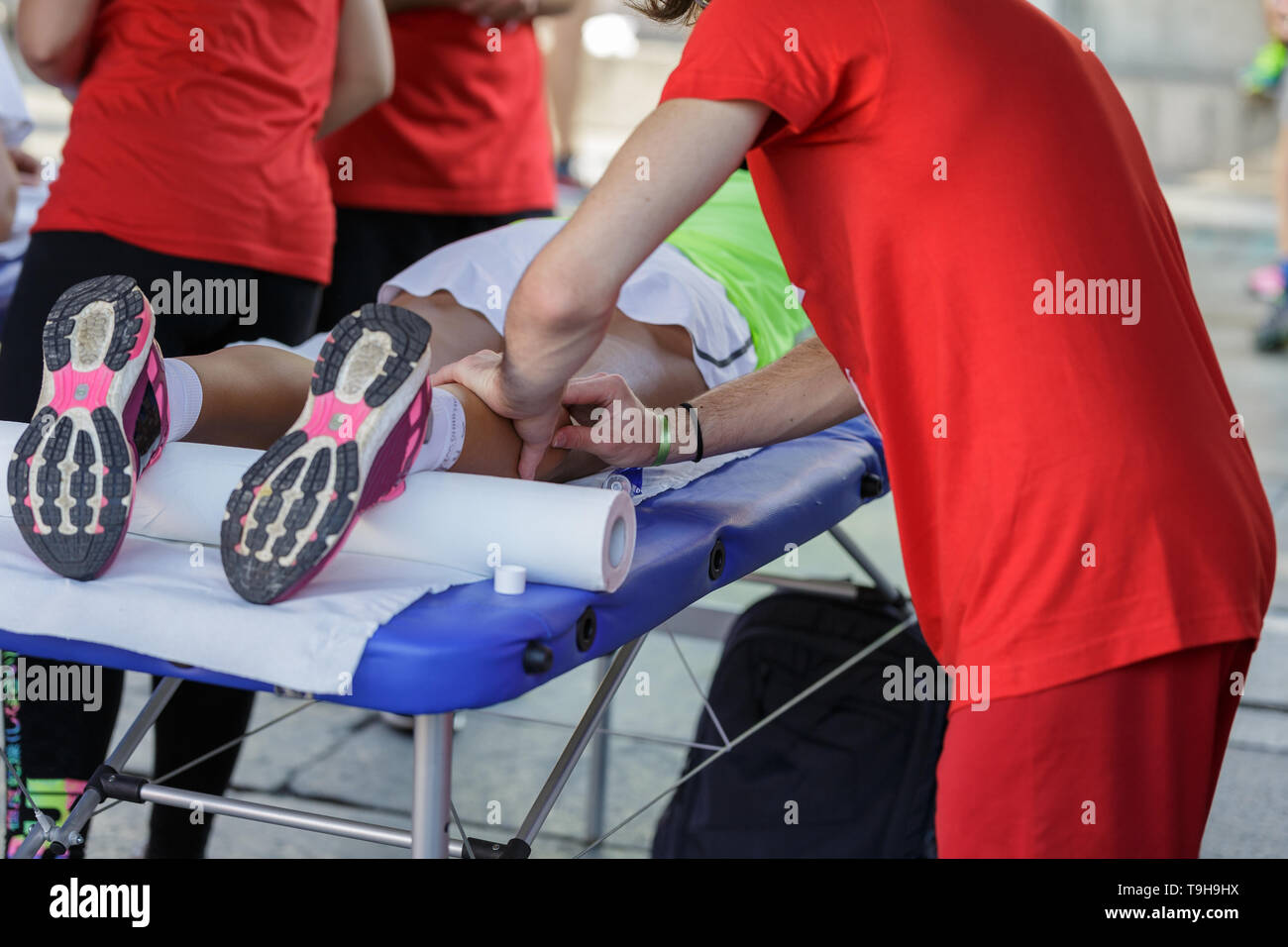 Athlete lying on a Bed while having Legs Massaged after a Physical