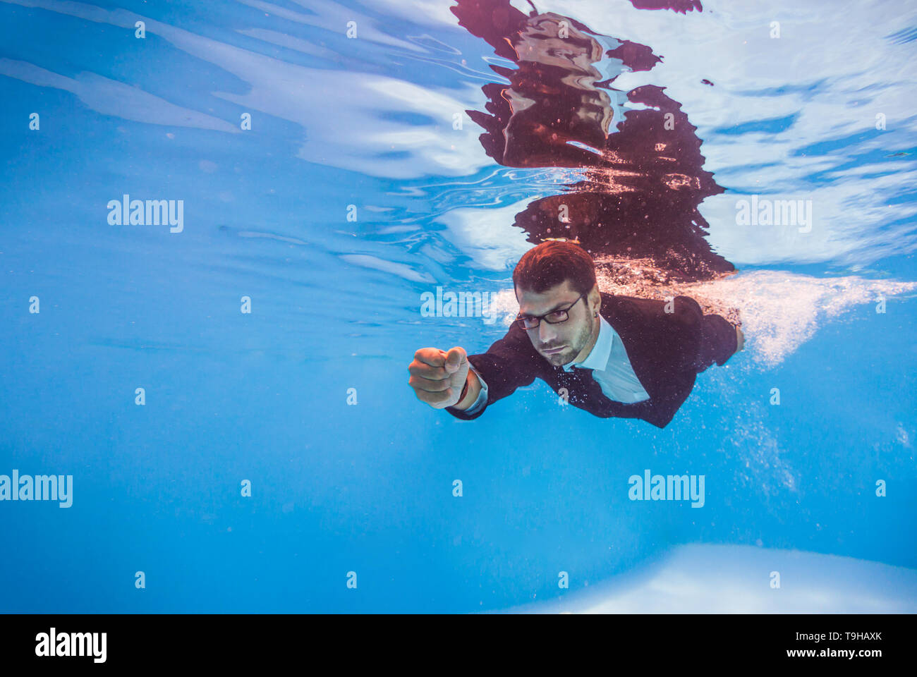 businessman swimming underwater in the pool Stock Photo