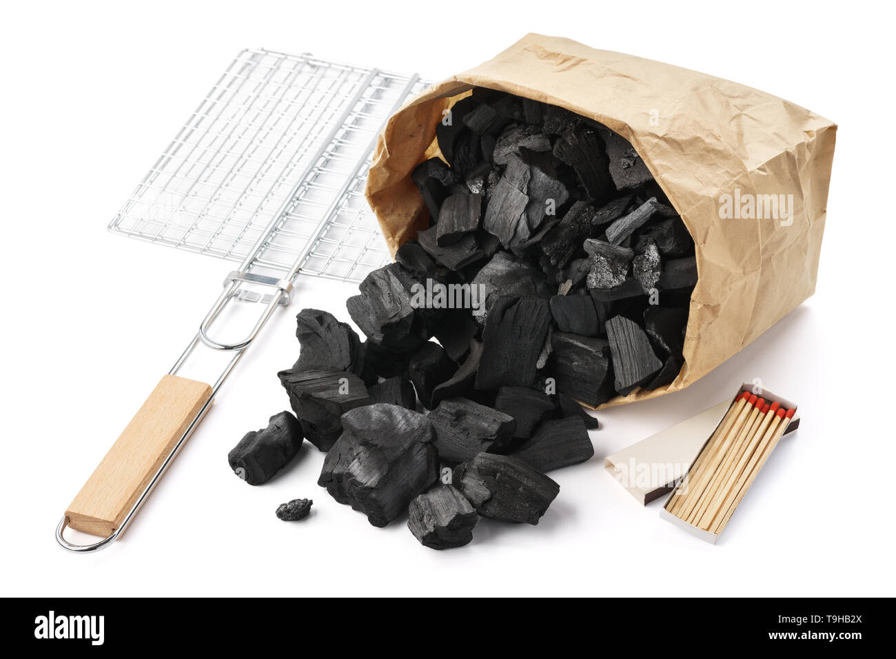 Set of tools and ingredients for barbecue. Paper bag of charcoal, grill and matches. Isolated. Stock Photo