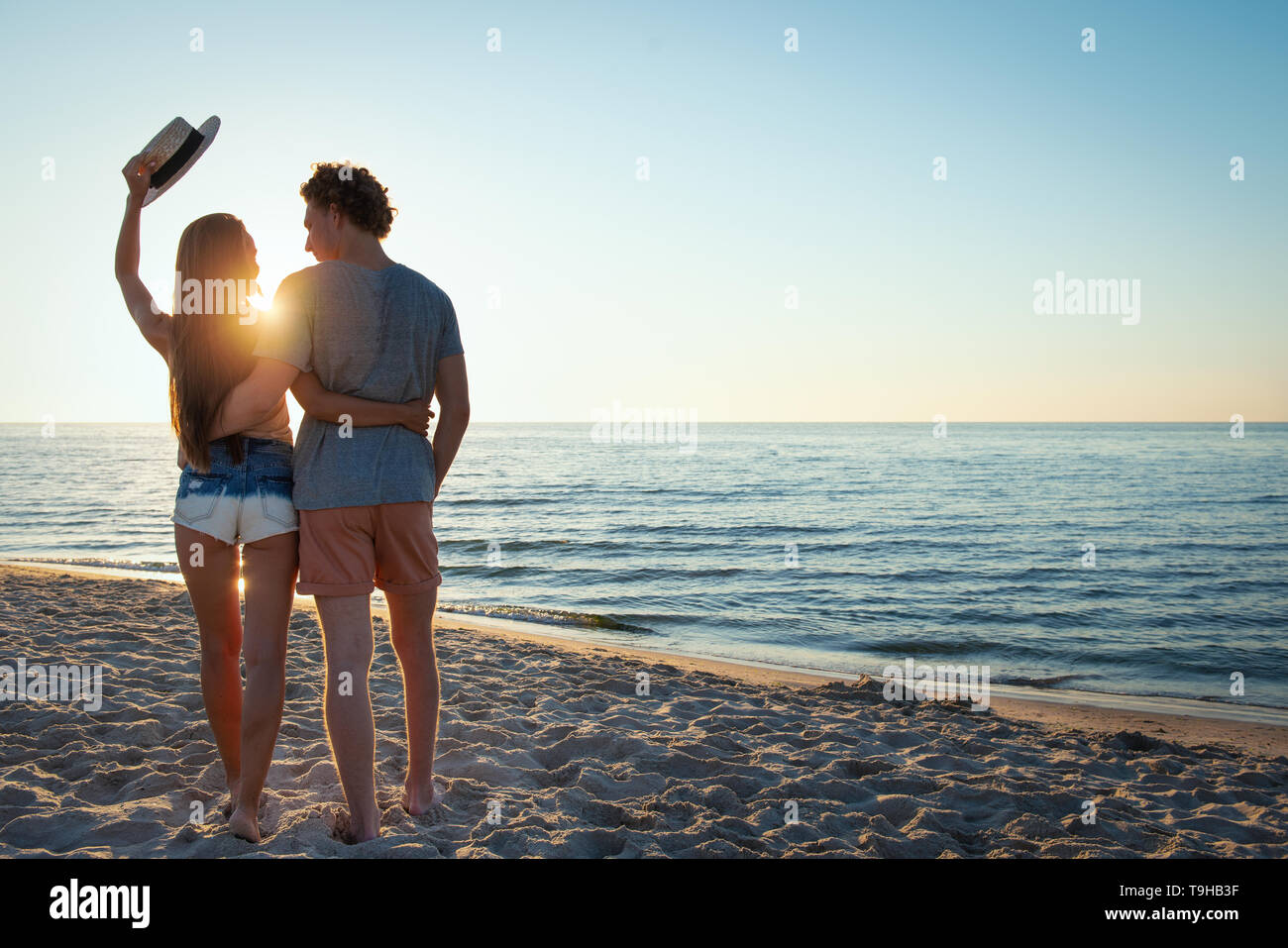 Couples during sunrise at the beach Stock Photo