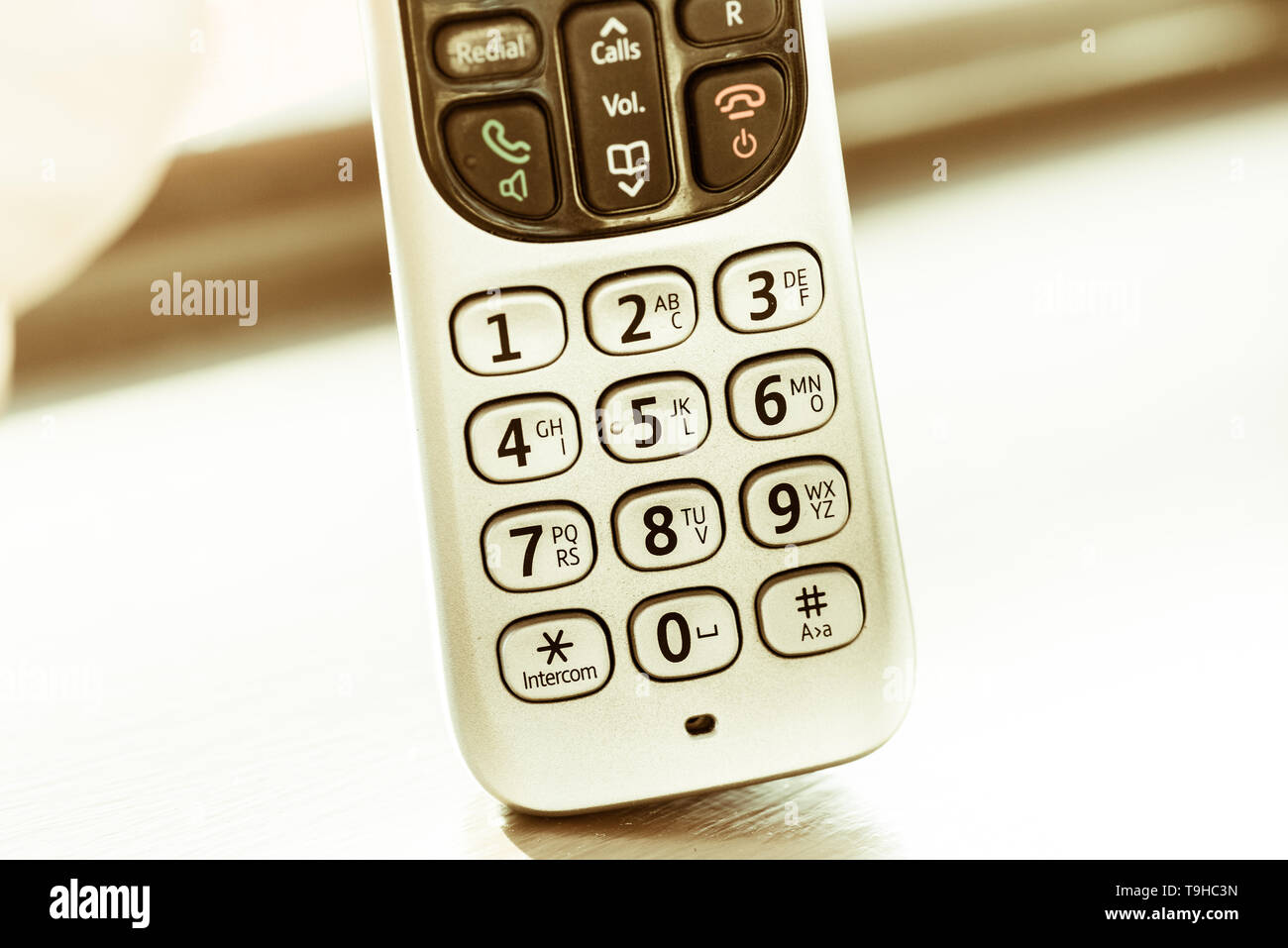 Traditional landline phone isolated on wooden desk background Stock