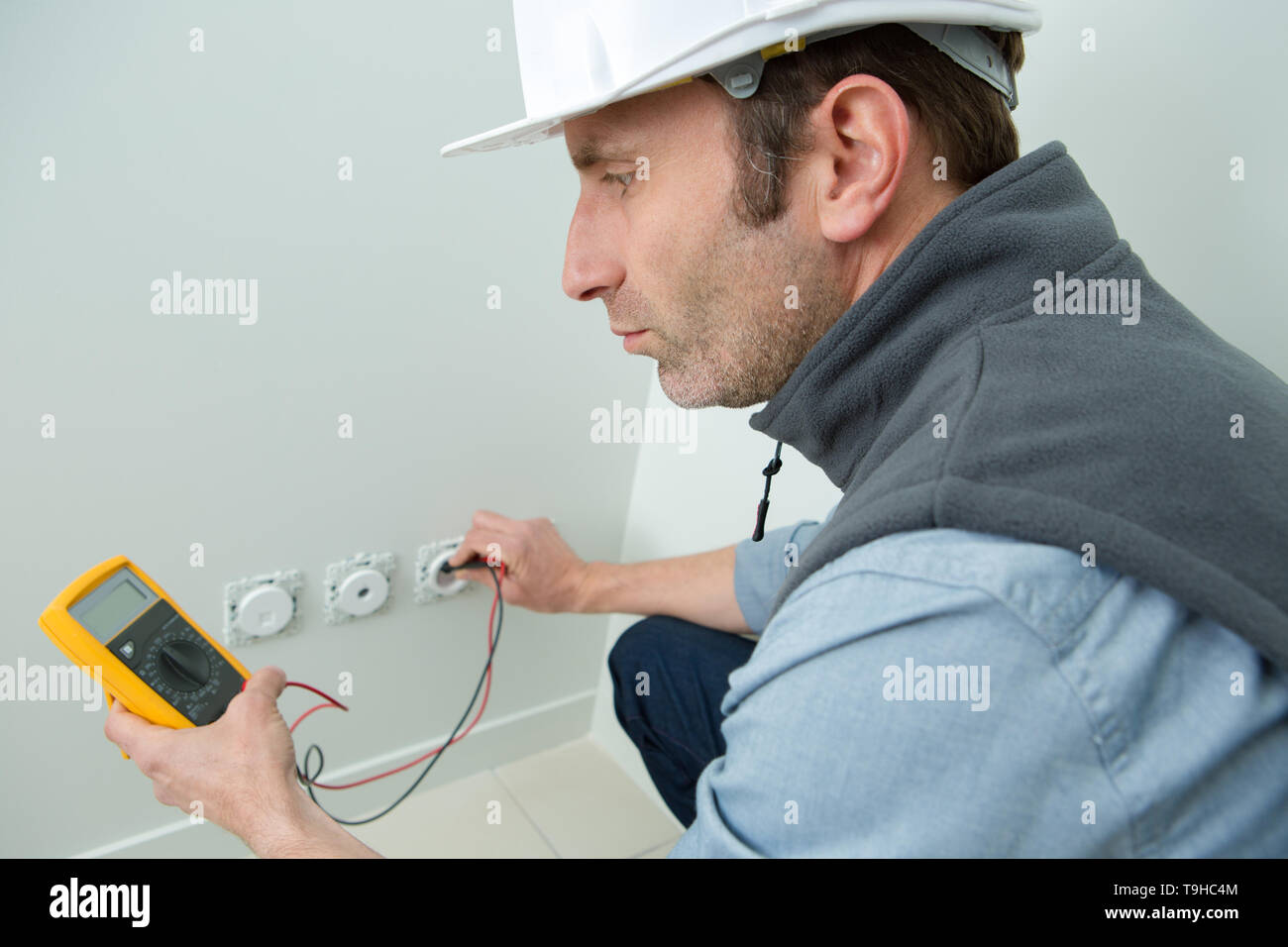 electrician testing electric socket with multimeter Stock Photo Alamy