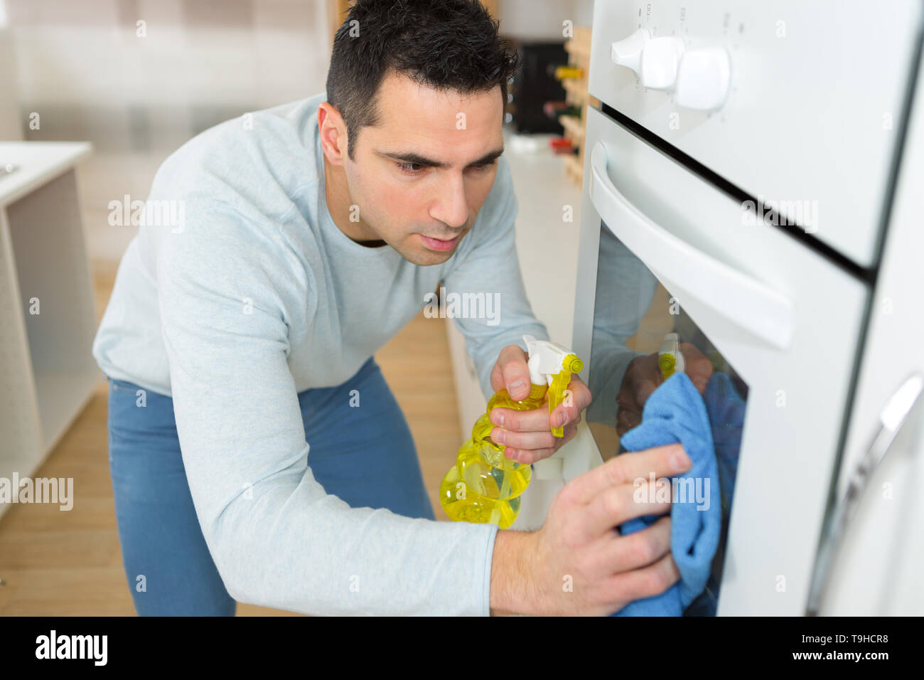 man earnestly cleaning oven in home Stock Photo