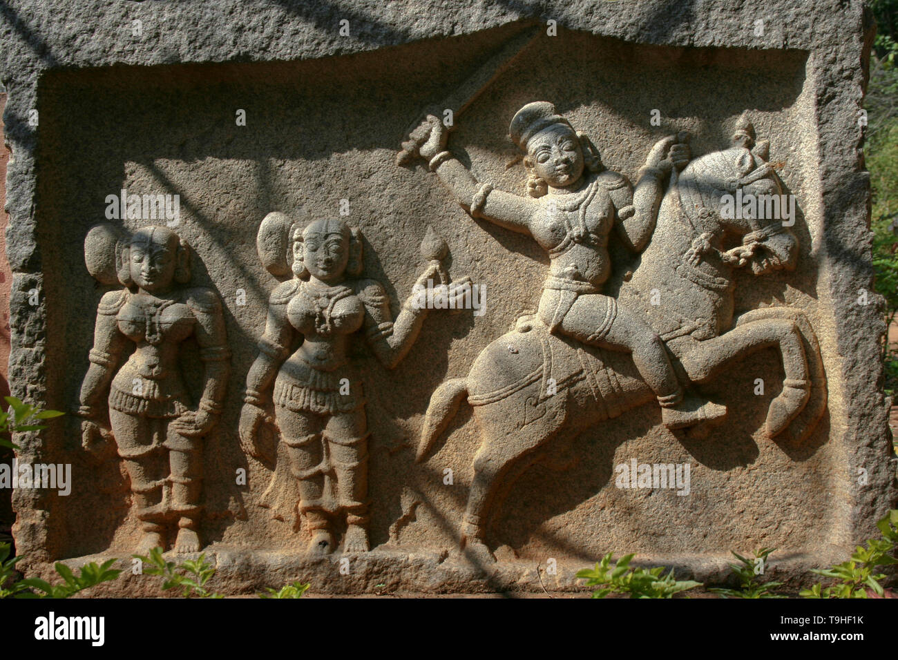 Stone etching of valorous Indian woman riding horse and fighting battle Stock Photo