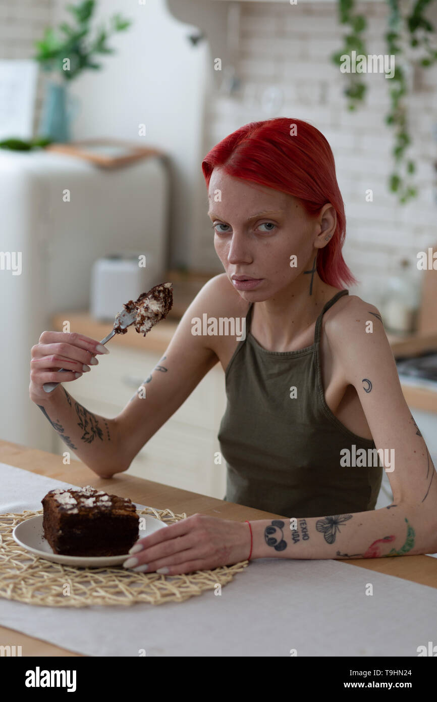 Woman feeling bad after long suffer from bulimia holding cake Stock Photo