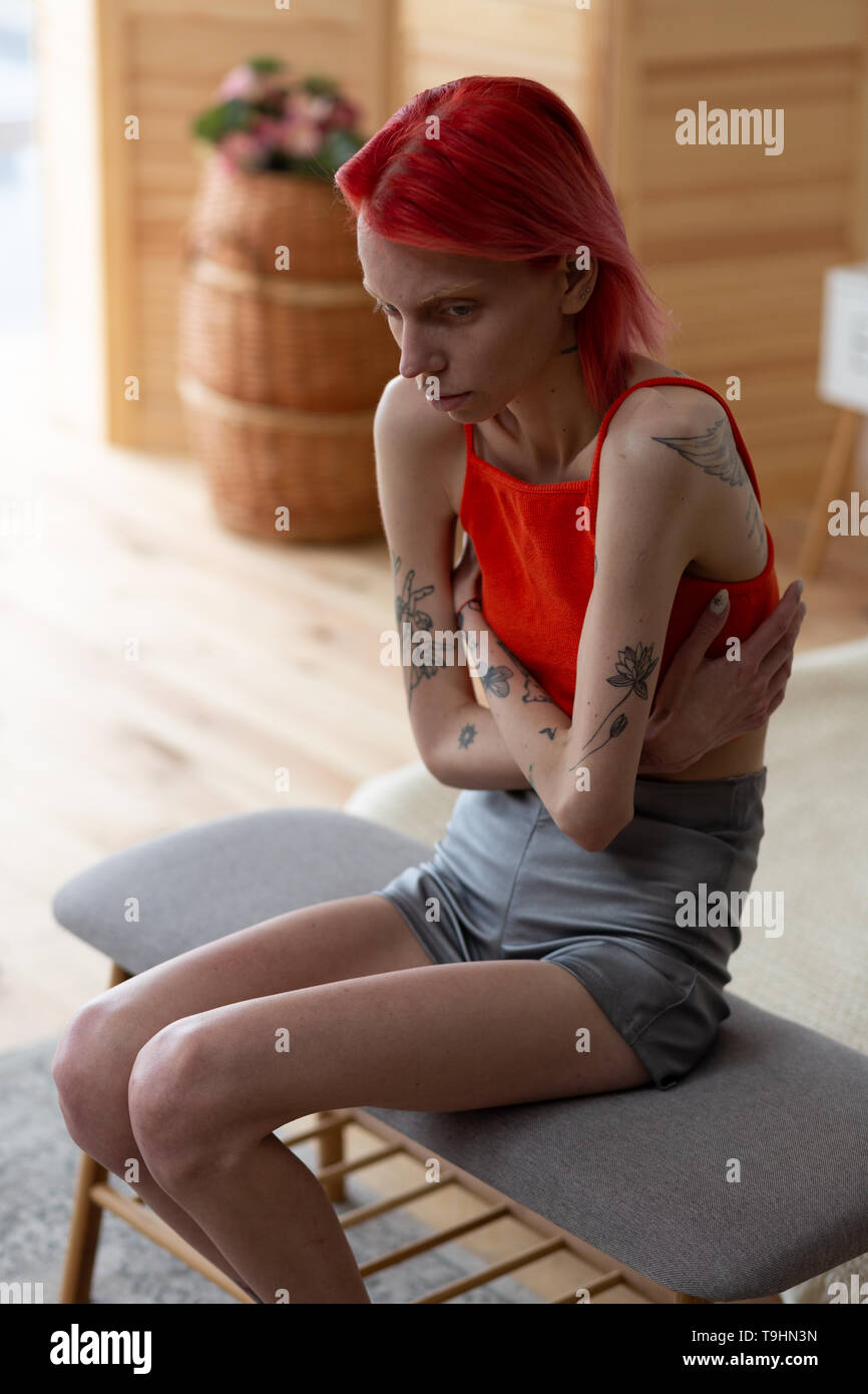 Skinny woman wearing shorts and top having strong pain Stock Photo - Alamy