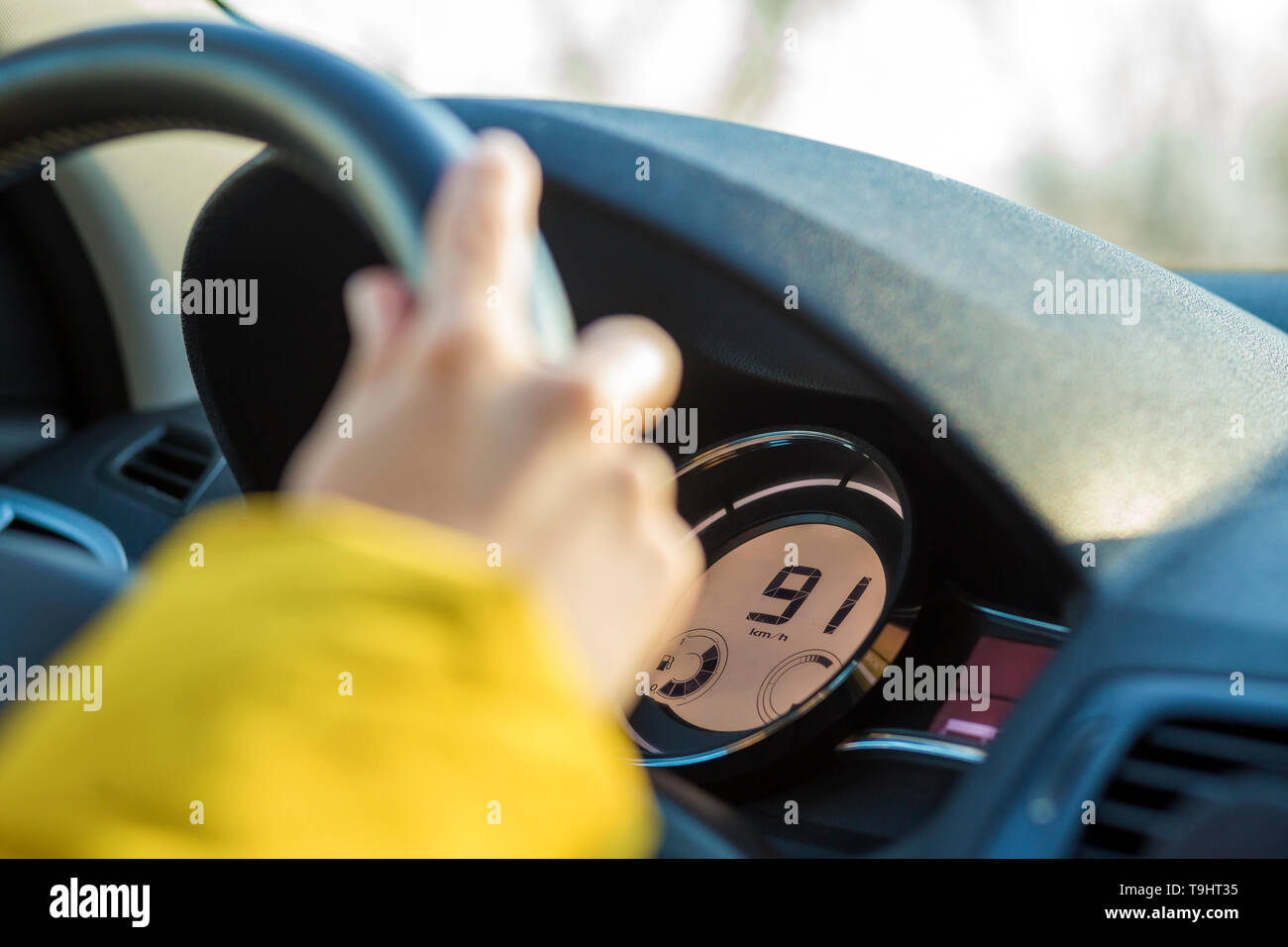 Modern car interior with driver hand on steering wheel. Safe driving