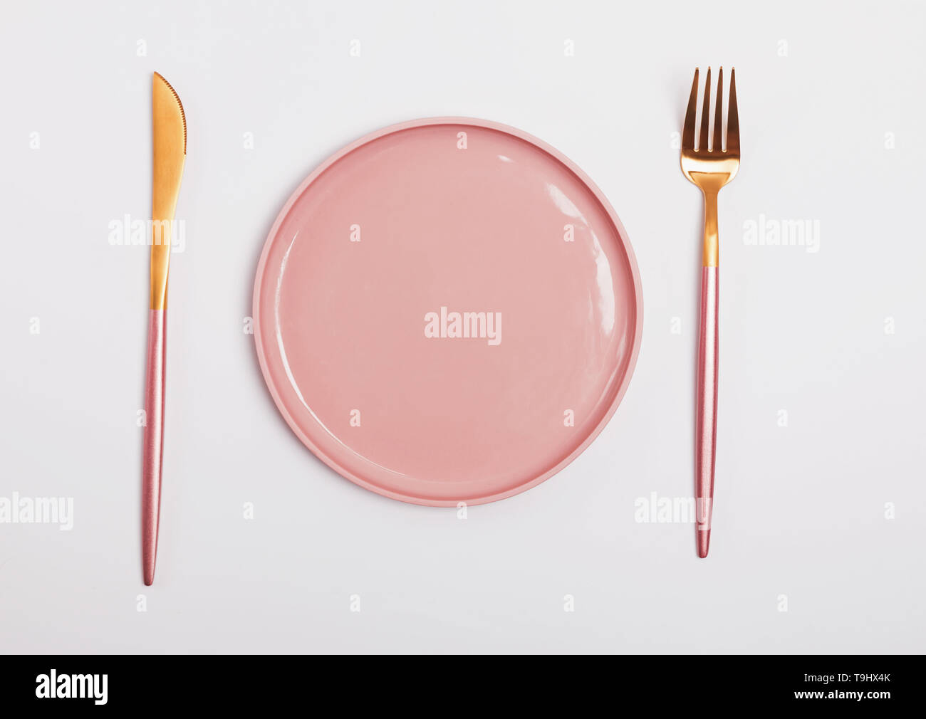 Pink plate, fork and knife isolated on white background, top view Stock ...