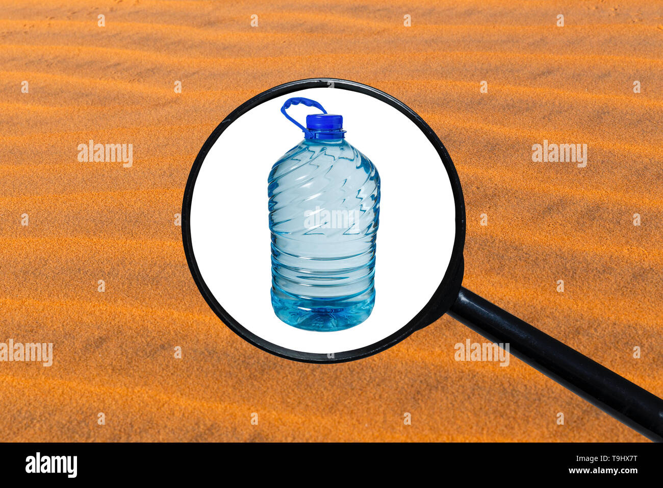 Big bottle of water isolated on a white background, view through a magnifying glass against the background of sand Stock Photo
