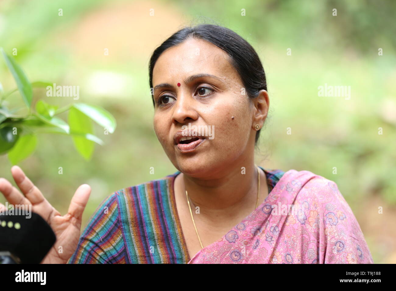 Adoor, India. 16th Apr, 2019. The communist politician Veena George stands  in front of an office of her party in a meadow. She is one of the few women  to run in