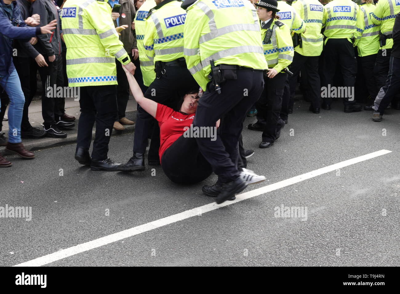 Liverpool, UK. 19th May 2019. Labour Councillor Ann O'Byrne being dragged along the floor by police as people protest against Tommy Robinson in Bootle ahead of this weeks European Elections. Credit:Ken Biggs/Alamy Live News Stock Photo