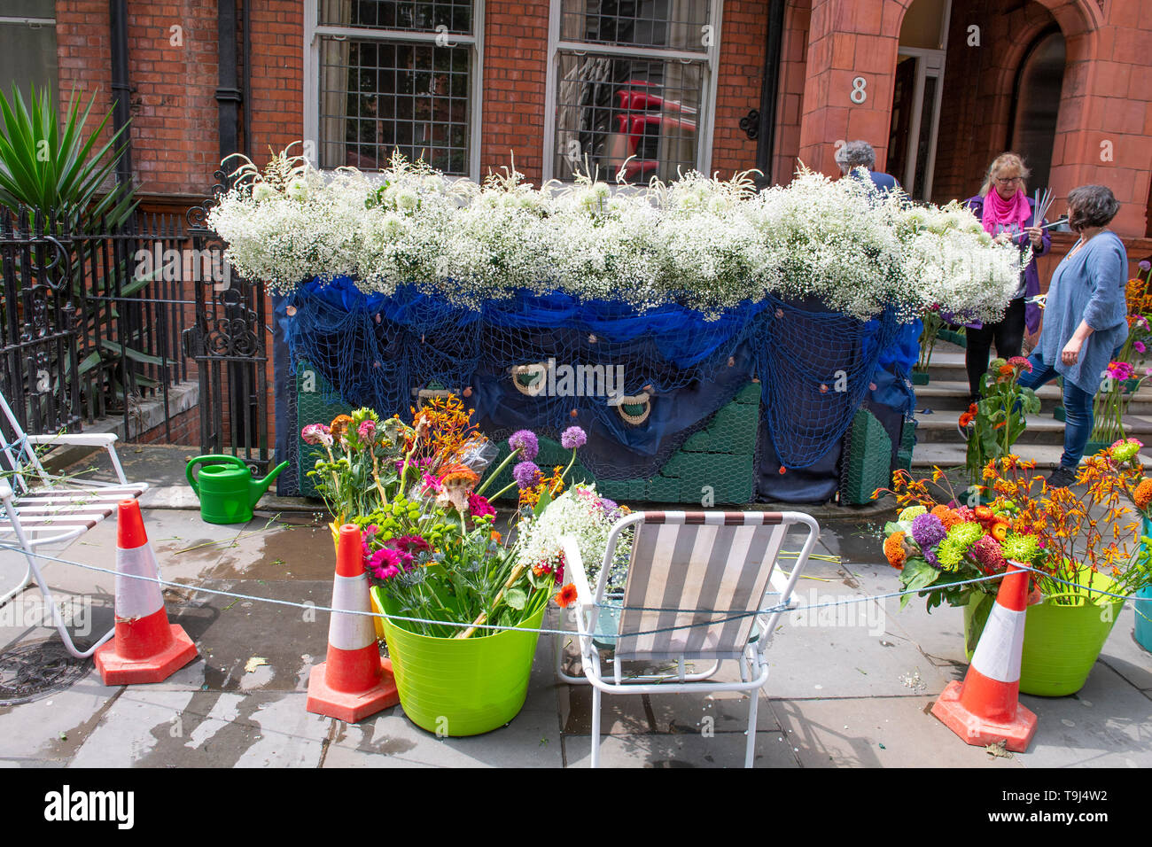 Royal Hospital Chelsea, London, UK. 19th May 2019. Chelsea Flower Show 2019 readies itself for judges before the public opening on 21st May with finishing touches to plant displays and gardens around the showground for Chelsea in Bloom. Image: Shops, residents and businesses in Chelsea decorate properties for the Flower Show week. The No 8 Dental Practice display being created. Credit: Malcolm Park/Alamy Live News. Stock Photo