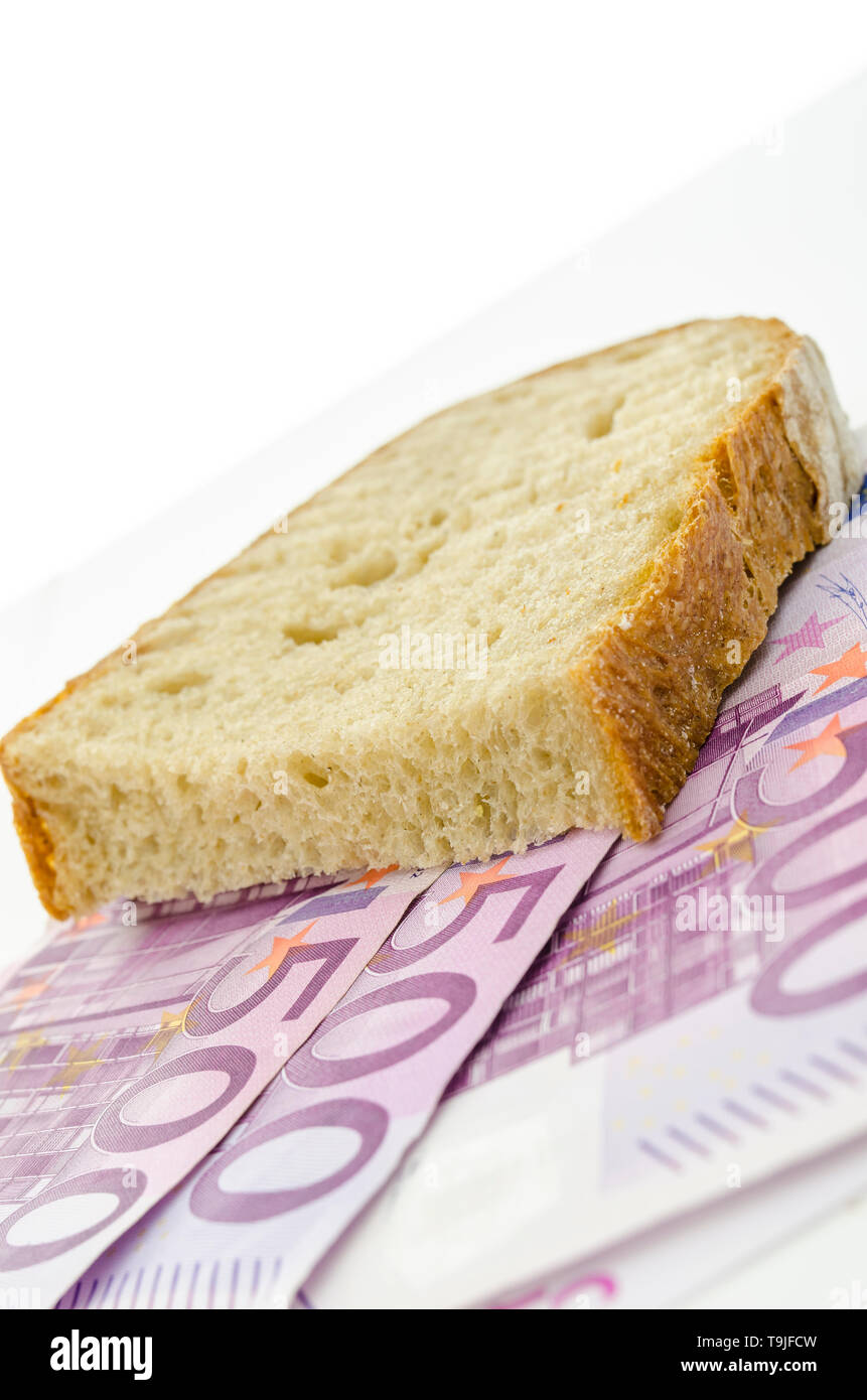 Piece of brad on Euro banknotes. Concept of large food expenses. Stock Photo