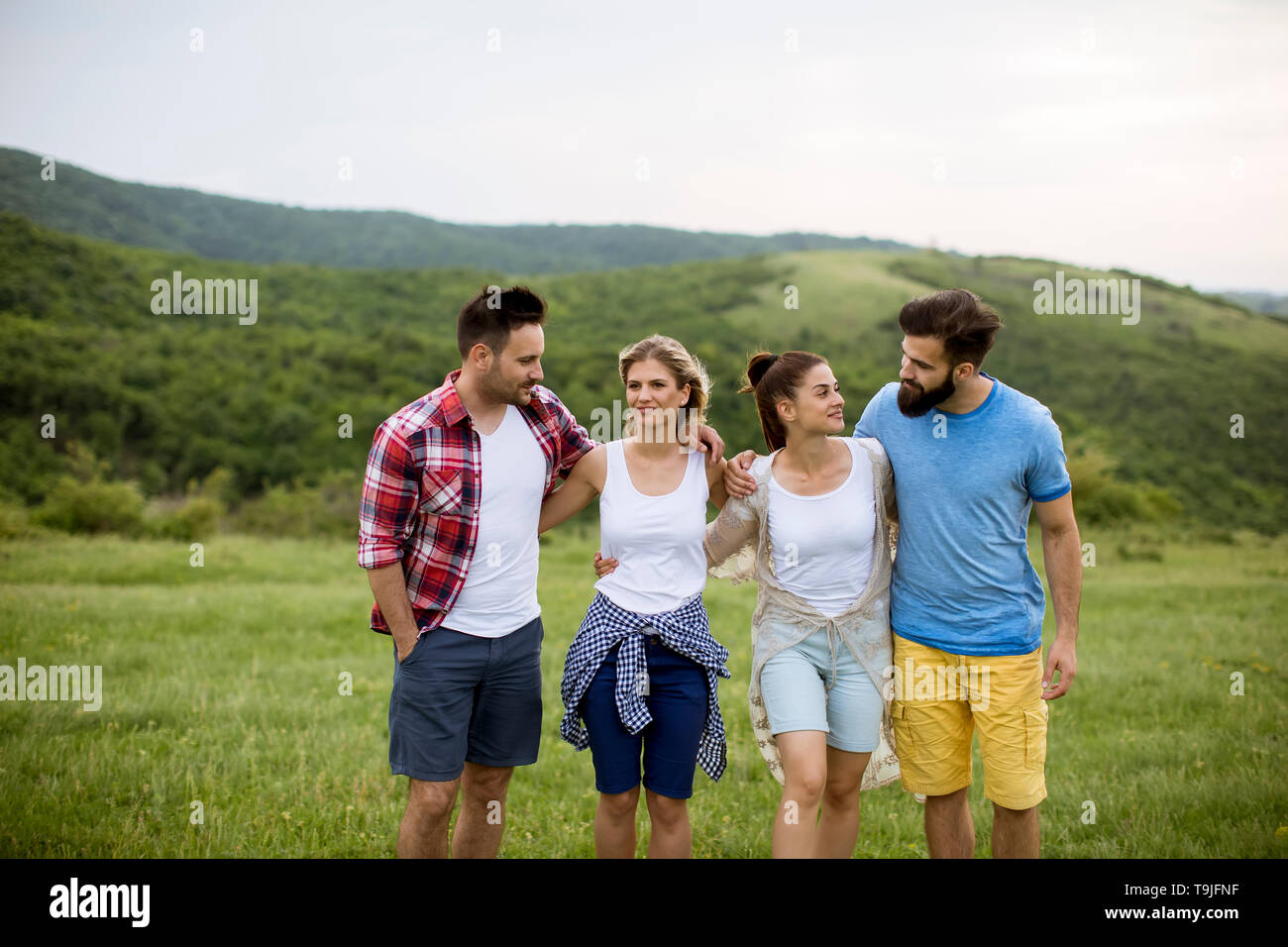 Four young people walking enjoying hi-res stock photography and images ...