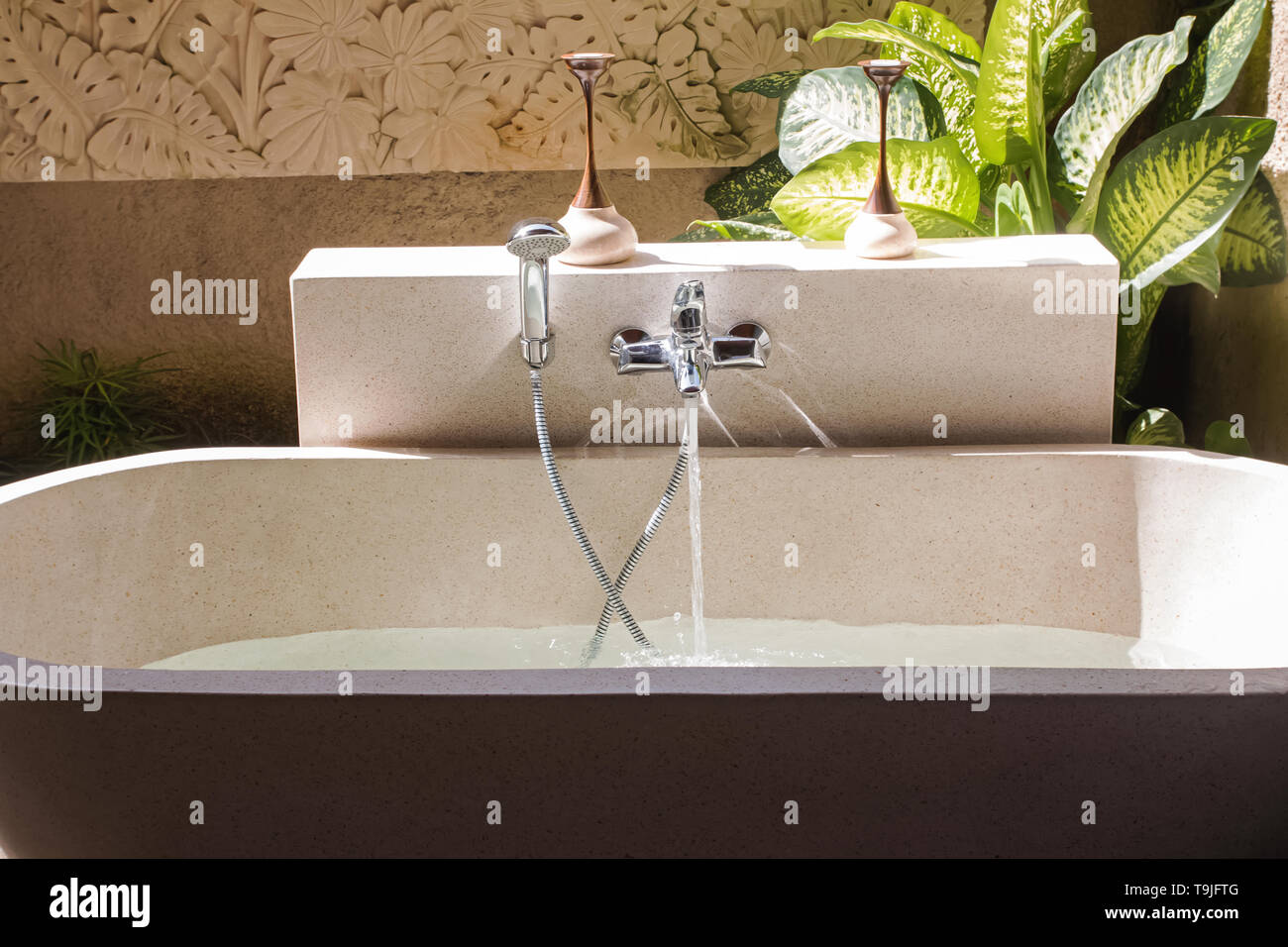 A bathtub filling with water from the tap on the moden luxury villa