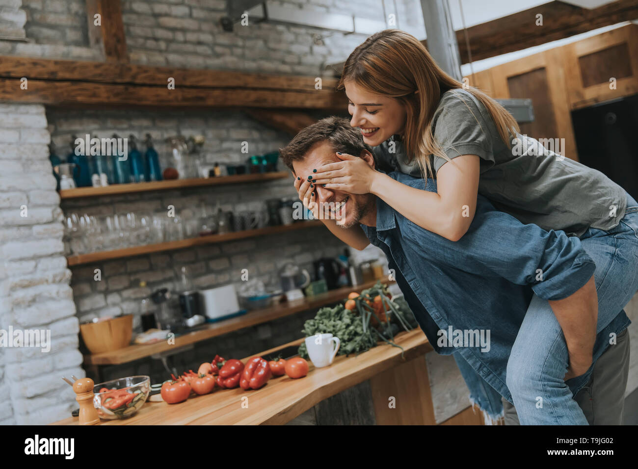 Lovely young couple having fun together at rustic kitchen Stock Photo