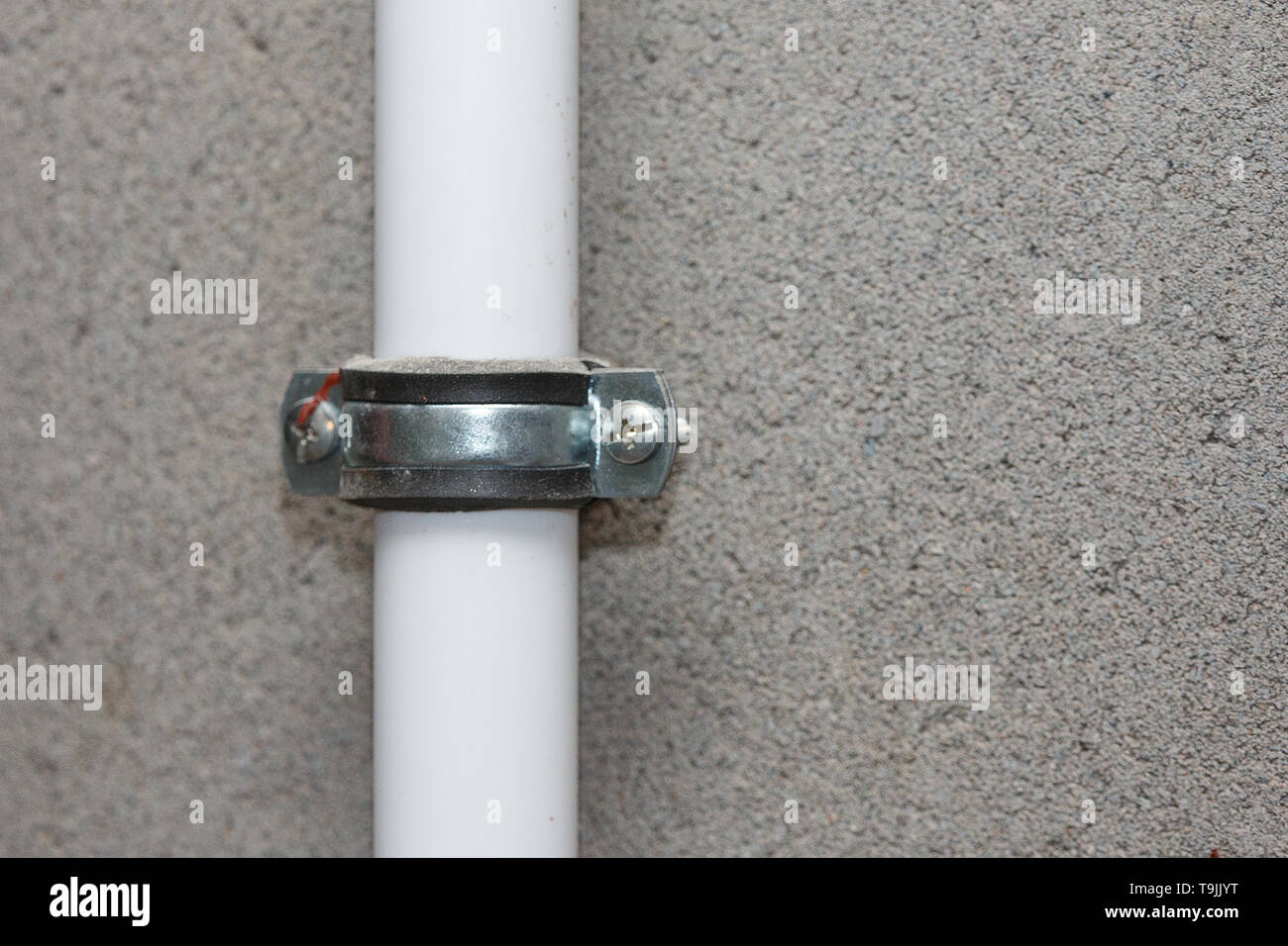 Fasten the white pipe to the concrete wall closeup Stock Photo Alamy