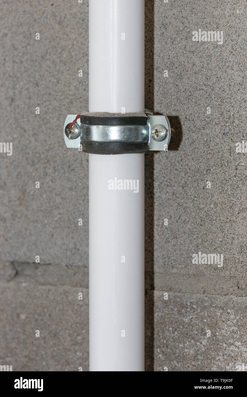 Fasten the white pipe to the concrete wall closeup Stock Photo Alamy