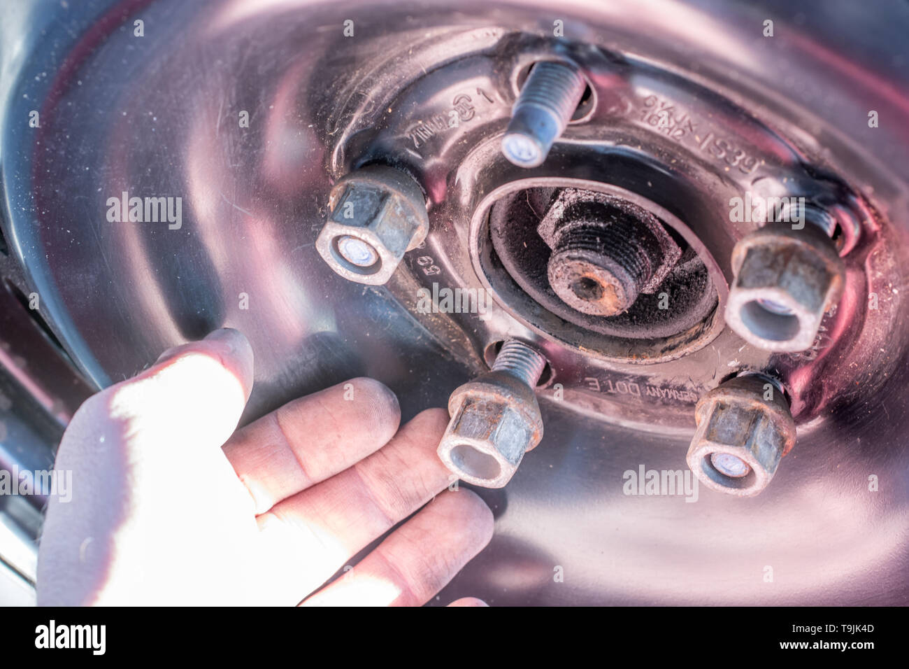 Wheel nut is loosened to change a tire Stock Photo