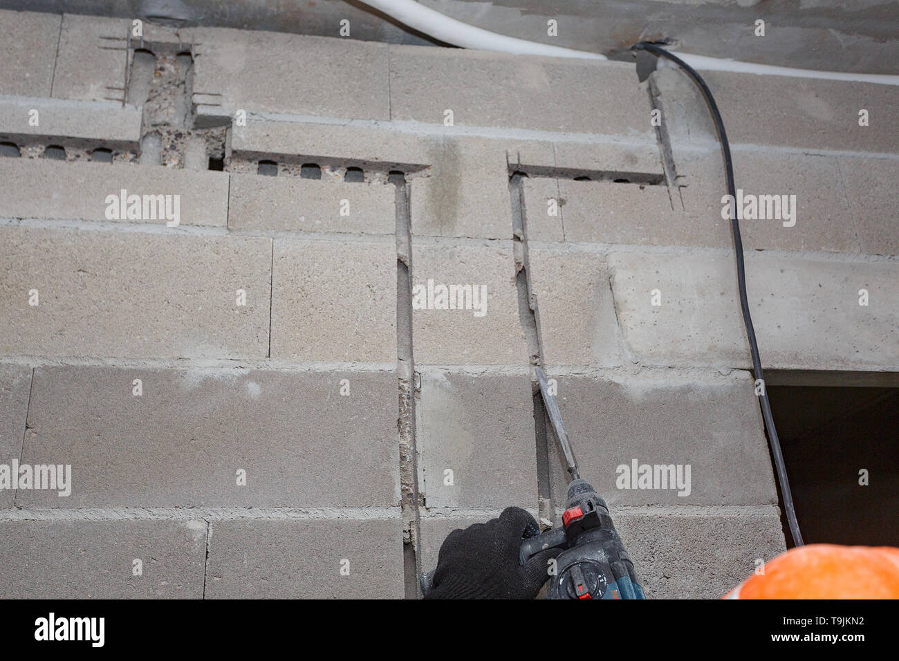 Slotting of the wall under the wiring with a perforator. Stock Photo