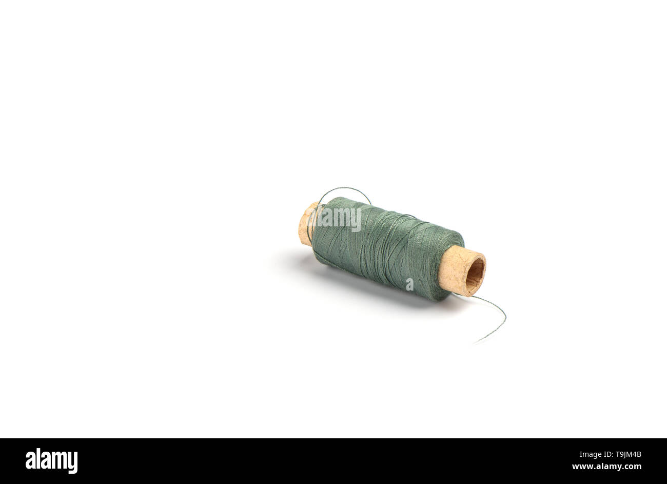 Cotton dark green threads on the cardboard sleeve for the sewing