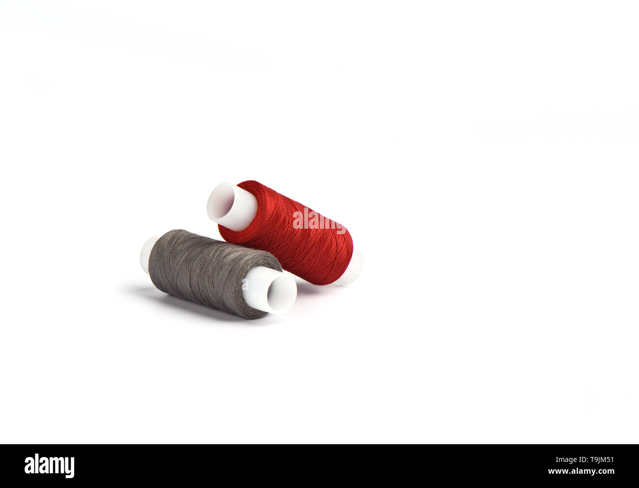 Cotton red and gray threads on the plastic sleeve for the sewing ...