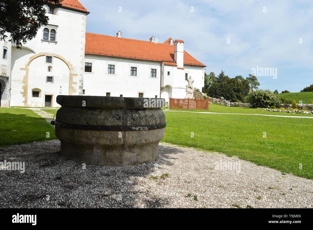 Medieval castle exterior with stone well in front Stock Photo