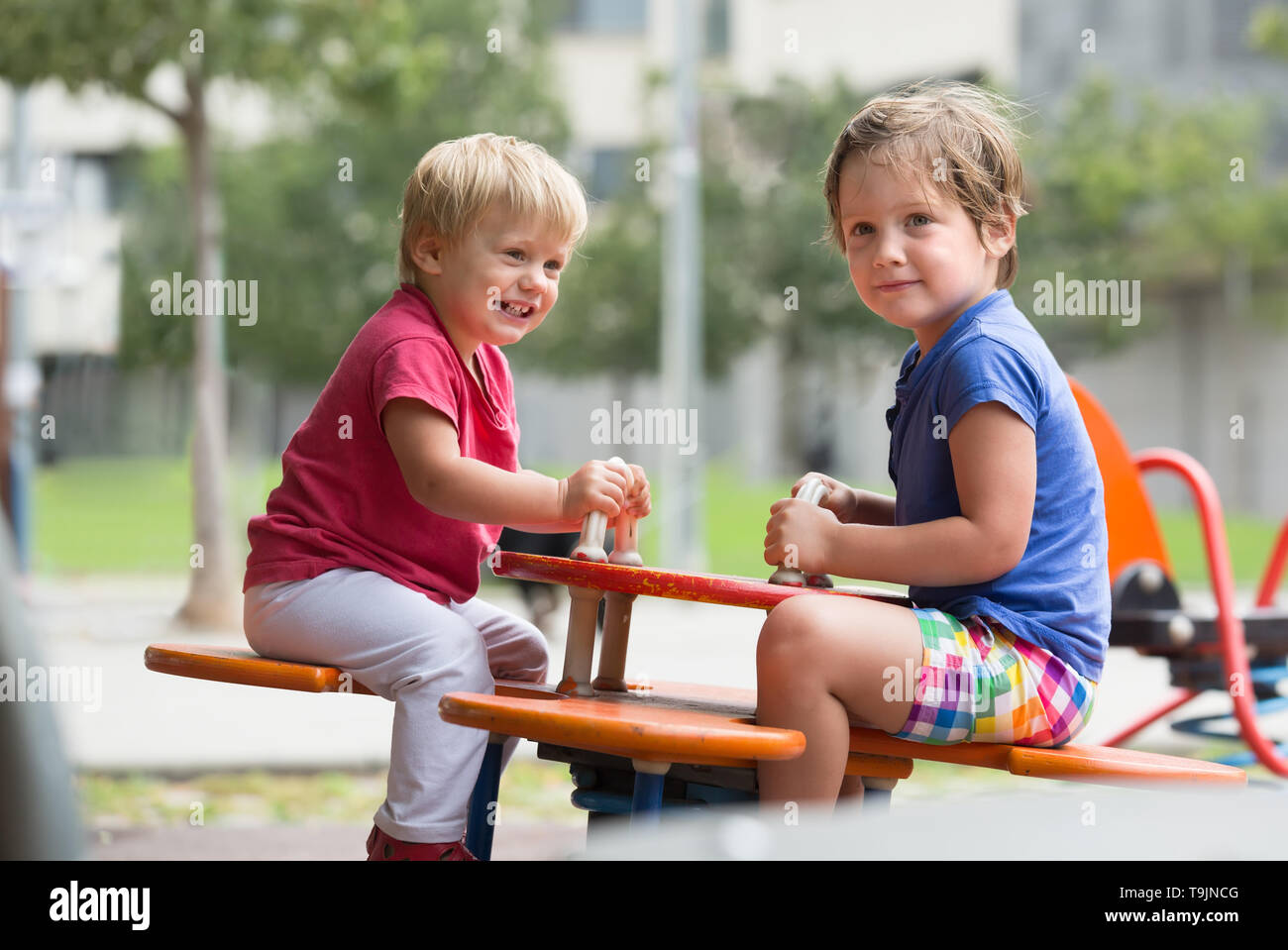 Happy smiling little siblings having fun at city playground Stock Photo ...