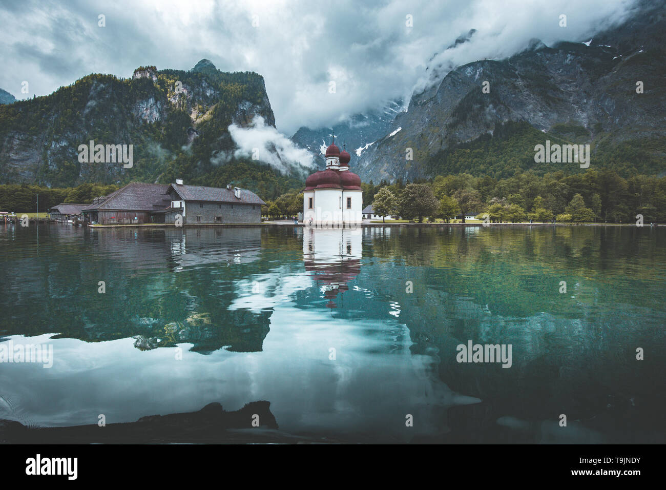 Classic panoramic view of Lake Konigssee with world famous Sankt Bartholomae pilgrimage church and Watzmann mountain on a beautiful sunny day in summe Stock Photo