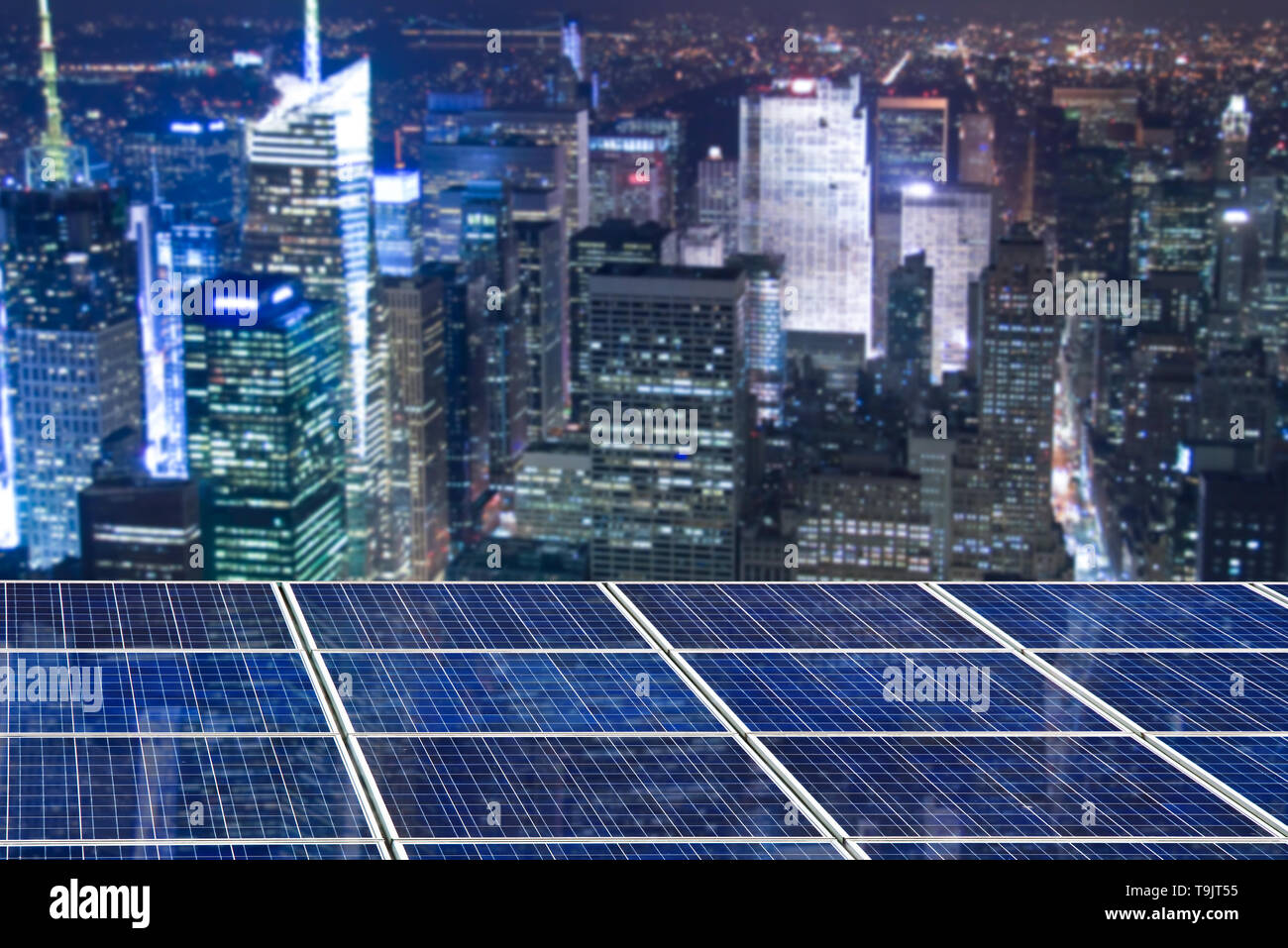 Blue solar cell panels, New York cityscape illuminated at night in the background Stock Photo