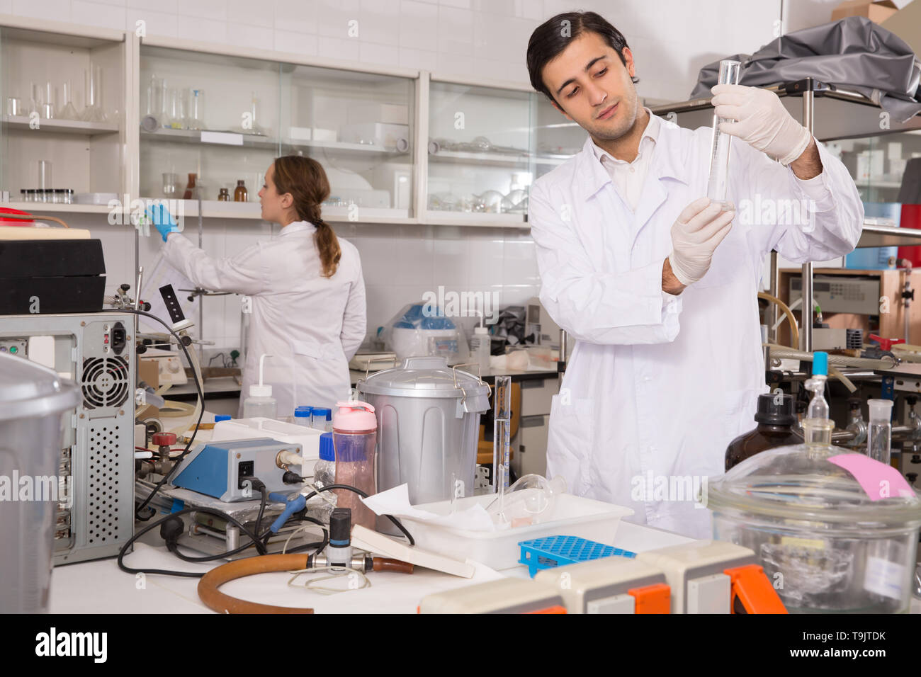 Male chemist working in laboratory, analyzing liquid samples in test flasks Stock Photo