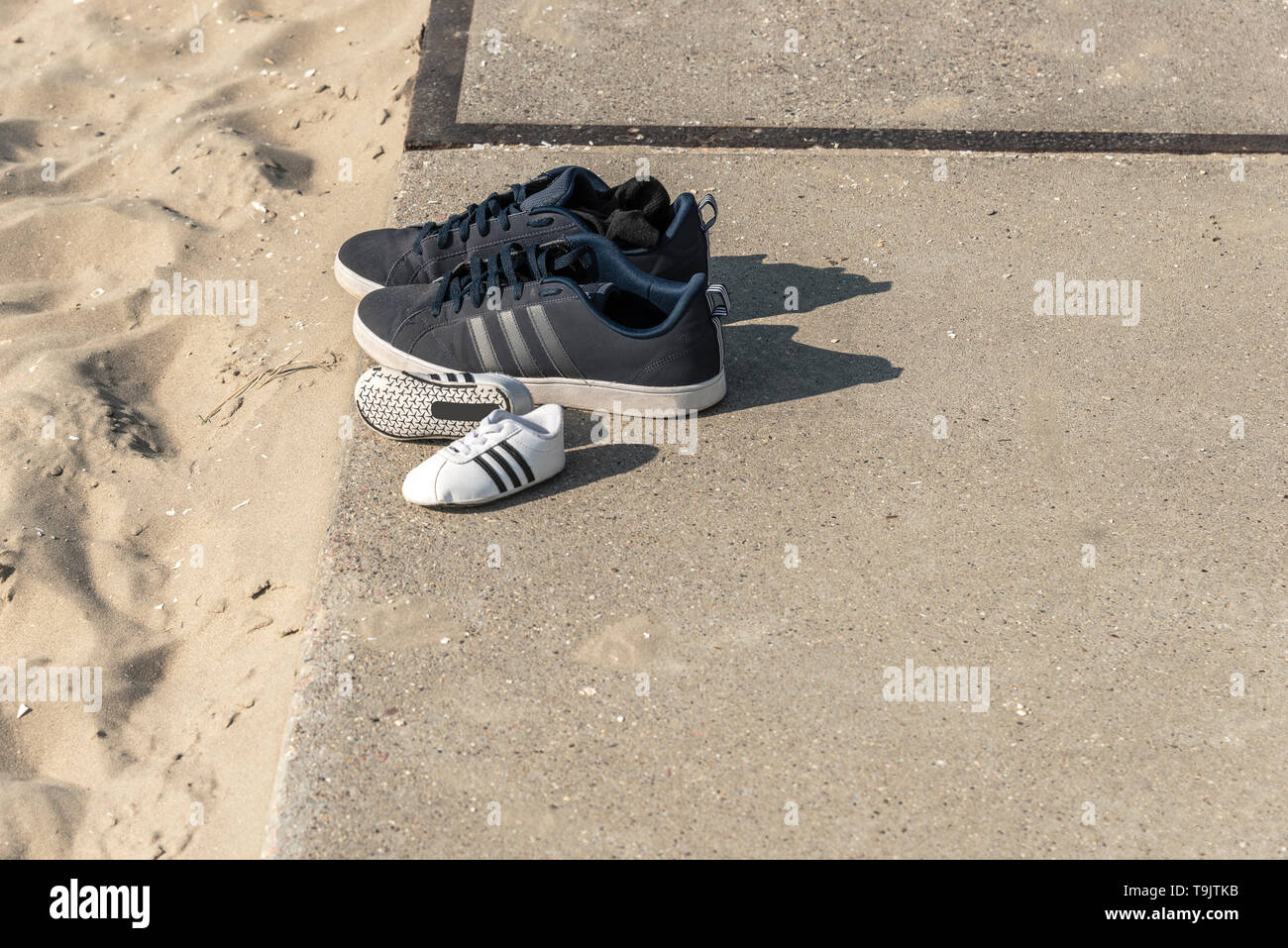 Two pair of sport shoes standing on a concrete slab near the beach Stock Photo Alamy