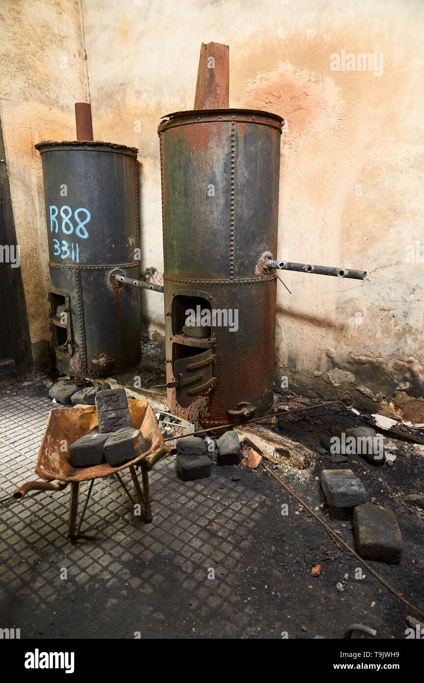 Interior of neglected facilities with rusty metal boilers and coal bricks at the Canfranc International railway station (Pyrenees,Huesca,Aragon,Spain) Stock Photo