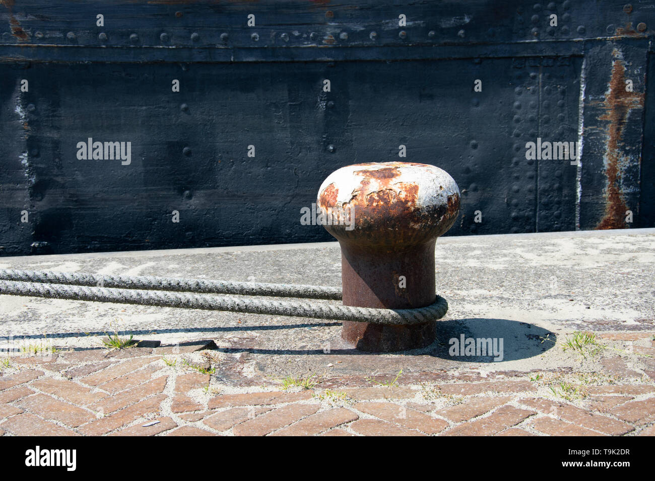 A rusty bollard with white paint on it Stock Photo