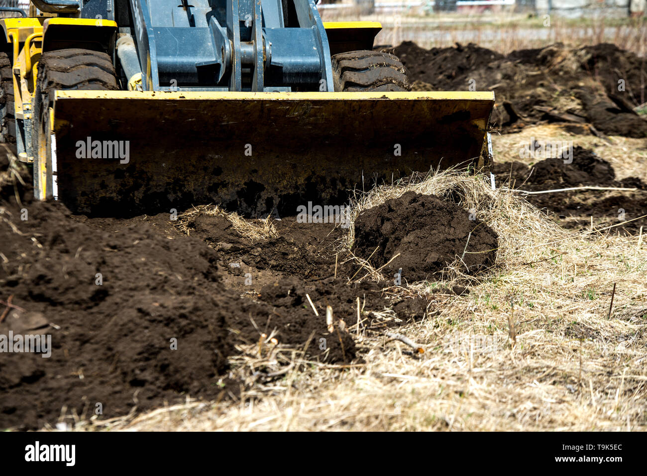 bulldozer pushes the ground, tractor pushes a lump of soil, preparing