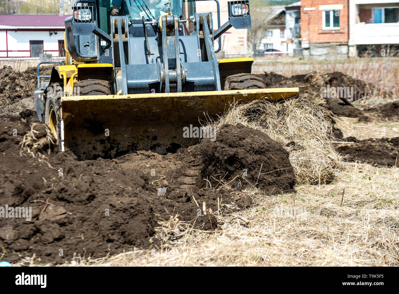 bulldozer pushes the ground, tractor pushes a lump of soil, preparing
