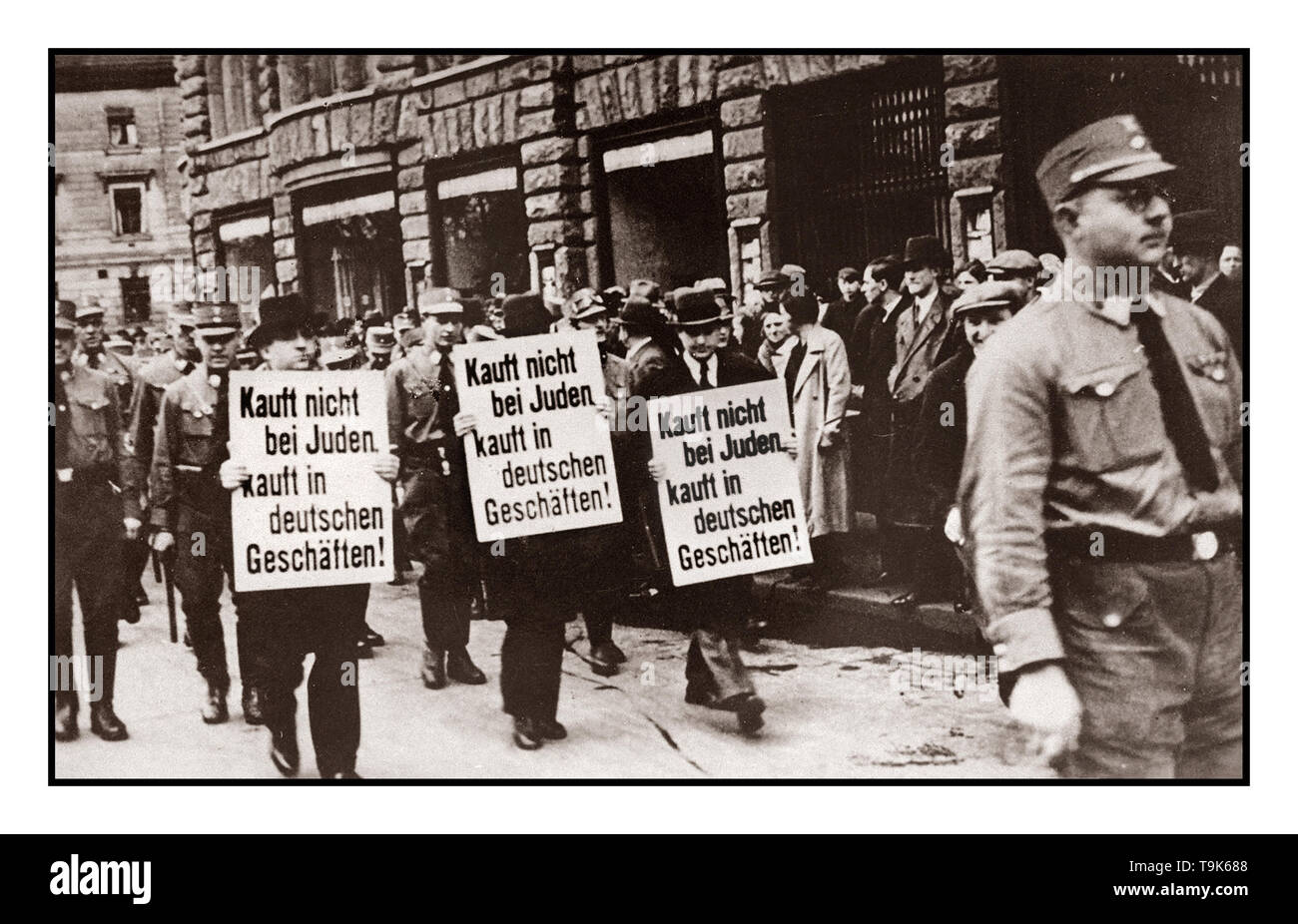 1930’s Boycott Jewish owned stores Anti Jewish racist Nazi propaganda image 1930’s Three Jewish businessmen are paraded down Bruehl Strasse by uniformed Nazi NSDAP Brown Shirts in central Leipzig, carrying signs that read: 'Don't buy from Jews; Shop at German stores!' Leipzig Germany Stock Photo