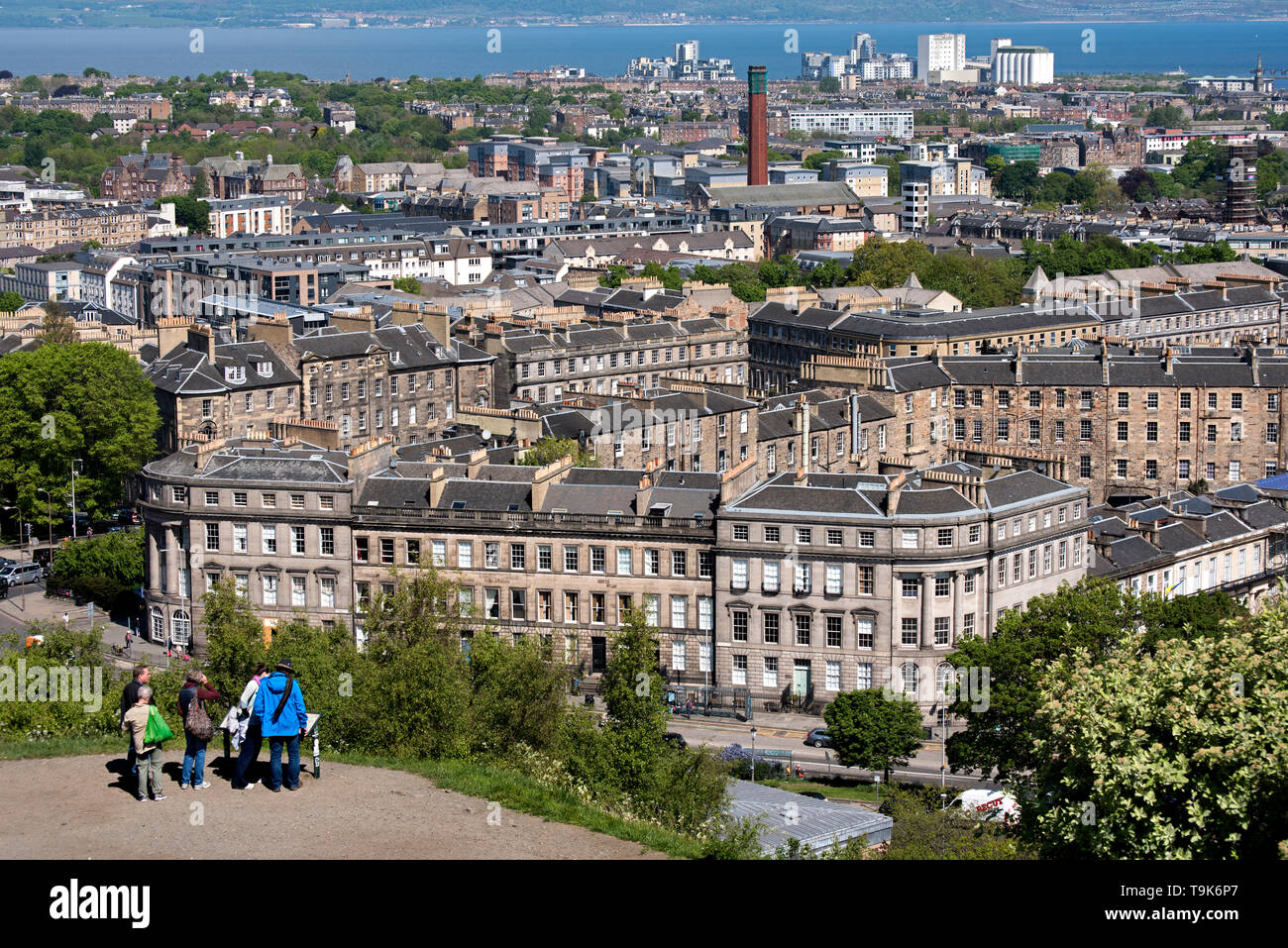 Tourists on Calton Hill take in the views of Leith, Leith and the Firth of Forth. Stock Photo
